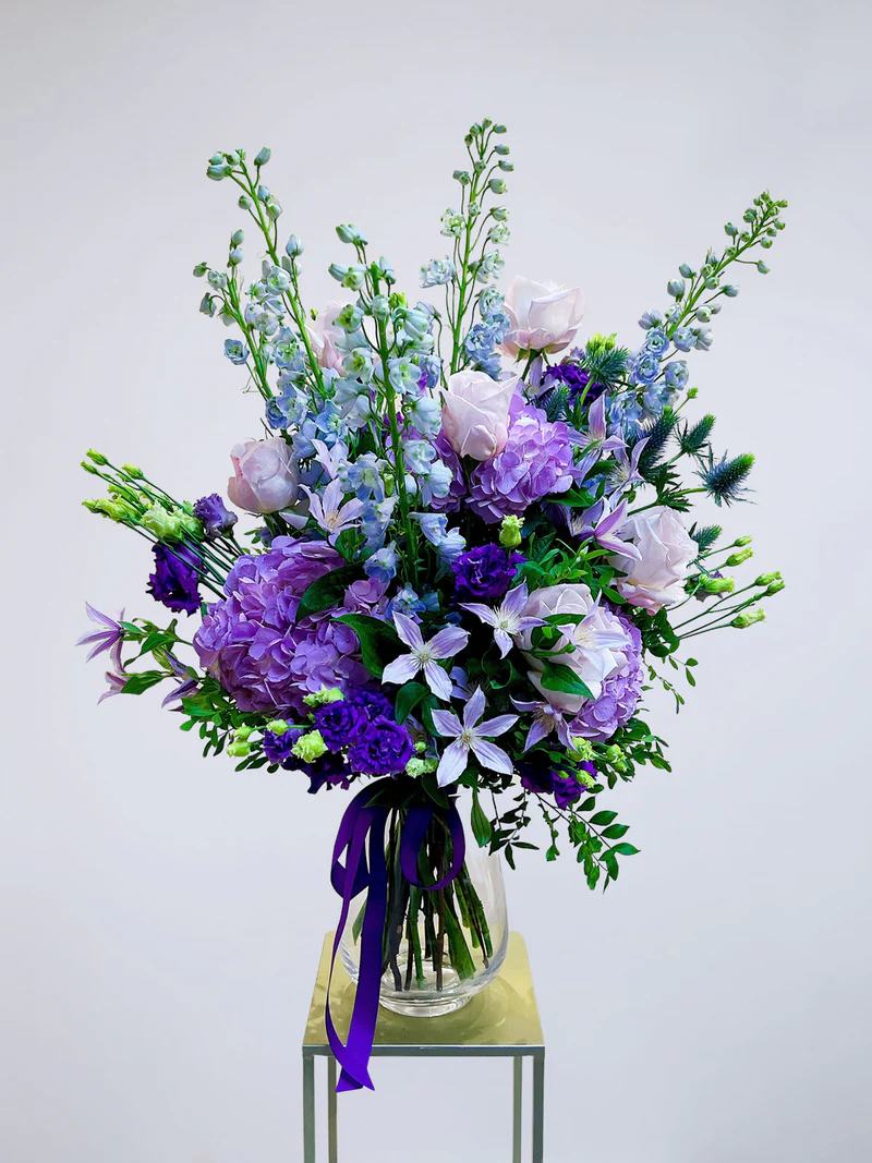 serenade  flower bouquet  - This gorgeous flower bouquet is a blend of fresh seasonal flowers in shades of purple and blue, orchestrated to perfection. Let these beautiful flowers serenade your senses and bring joy to your loved one's heart.
