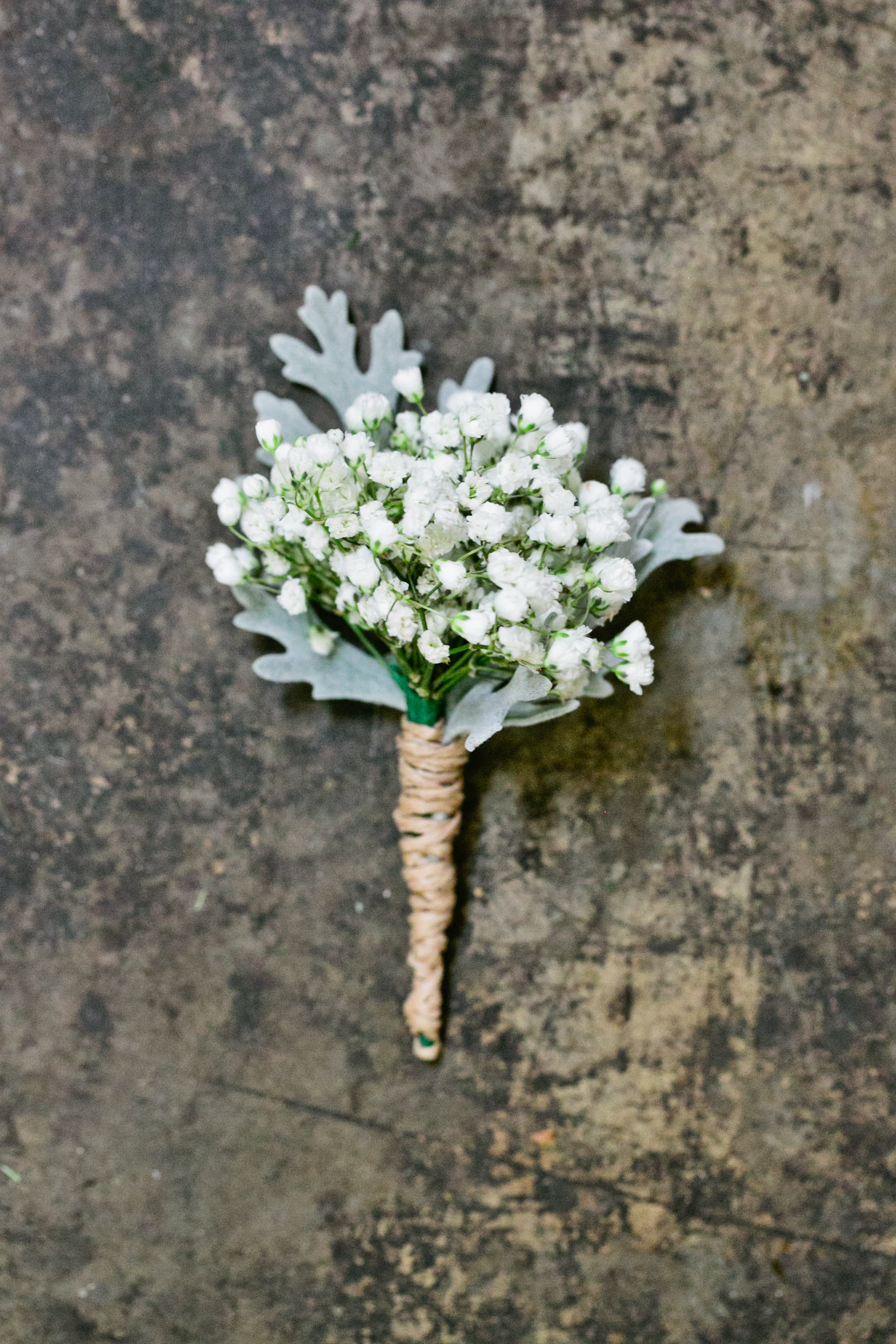 Country Boutonniere Country Boutonniere - Select this country boutonniere of babies breath and dusty miller with a natural stem wrap.