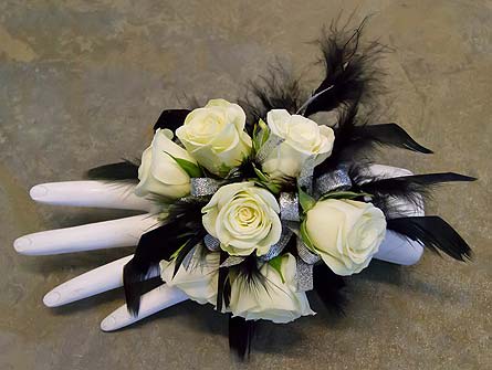 Dark Angel Wristlet Dark Angel Wristlet - This unique wristlet is made with 7 miniture white roses and accented with black feathers. As Shown : DSC09206