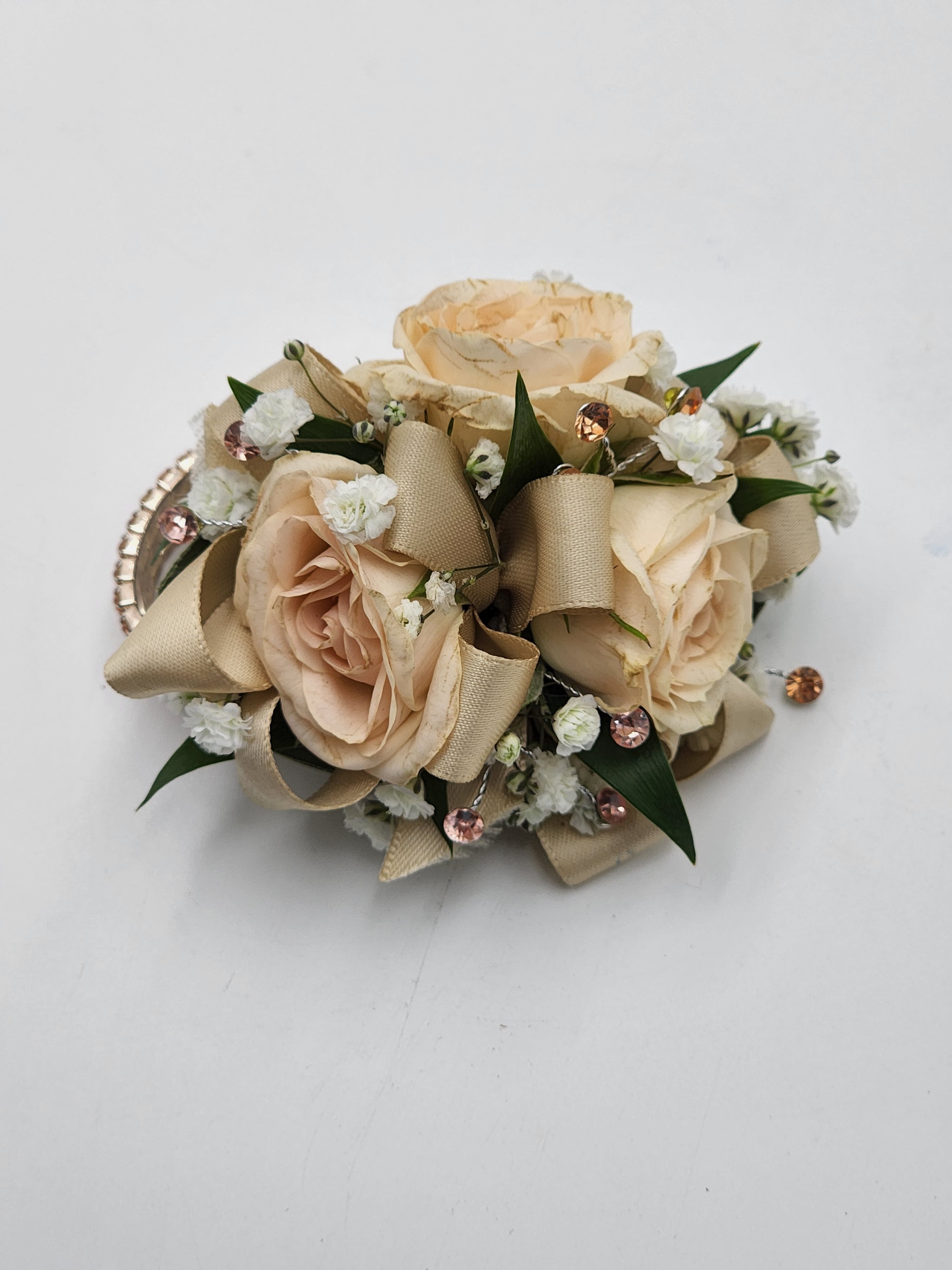 Peaches and Cream Wristlet Peaches and Cream Wristlet - A wrist corsage featuring peach spray roses, peach ribbon and peach rhinestones. Depending on availability of ribbon, may change slightly.