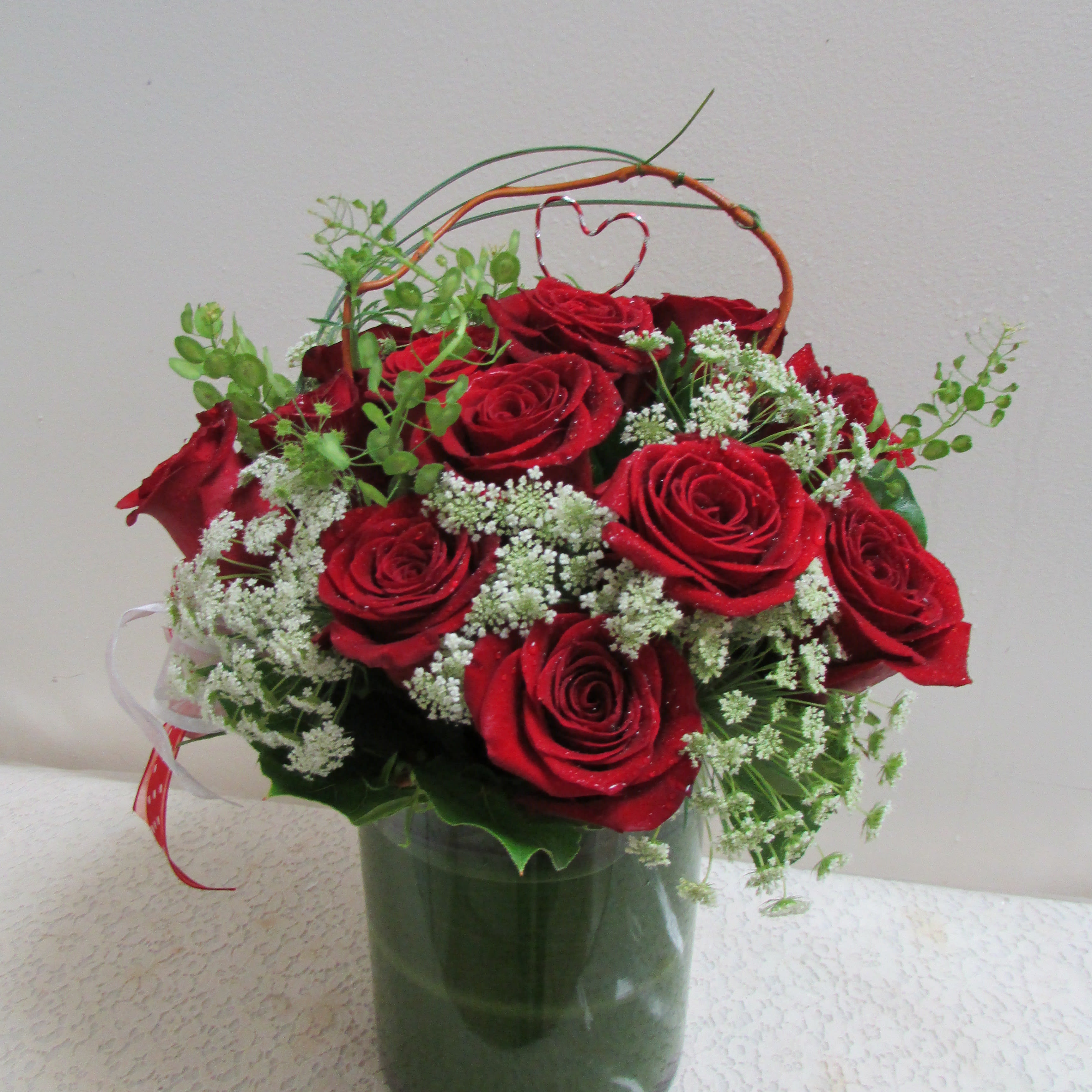 Sweet Rosy Red - Fifteen short roses arranged with greens in a short clear vase.