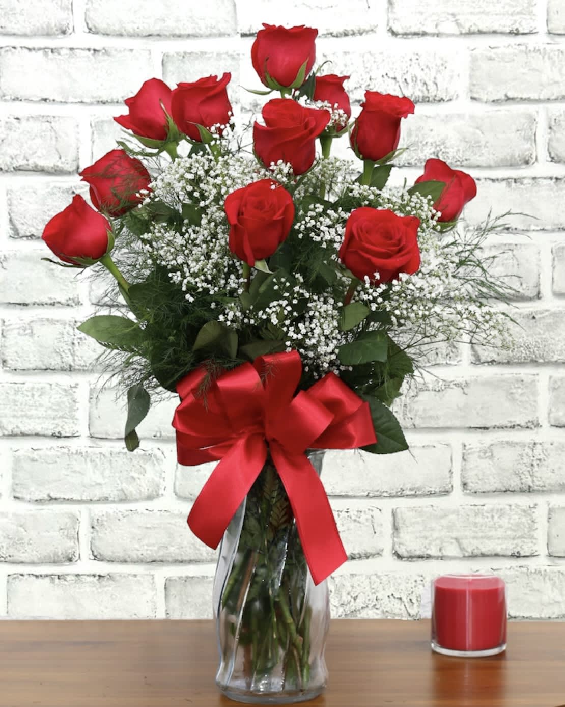 Classic Red Rose Dozen FG103R - A classically gorgeous arrangement of a dozen red Roses. Deluxe -- includes premium foliage. Premium -- includes premium foliage and premium accent flowers.  Approximately 8&quot; W X 18&quot; H