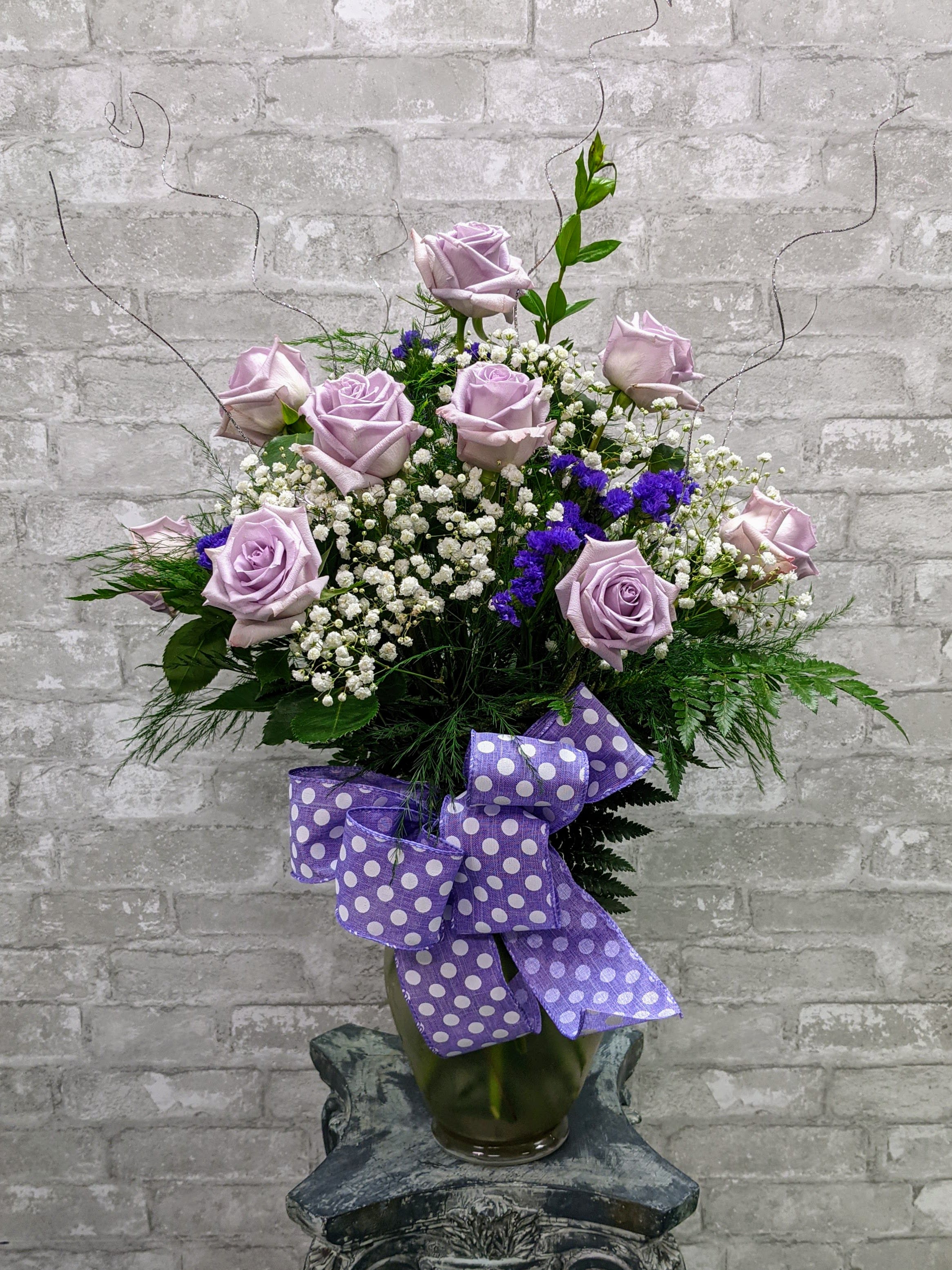 Bensalem's Best Dozen Lavender Roses FG114 - Twelve premium long stemmed roses designed in an attractive vase and accented with pretty bow and sparkling ting to finish the &quot;WOW&quot; effect. Deluxe includes premium foliage. Premium includes premium foliage and premium accent flowers. 27&quot; H x 21&quot; W