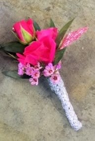 Barbie Princess Boutonniere Barbie Princess Boutonniere - Select this bright boutonniere consisting of barbie pink roses and pink filler flowers with a pale pink metallic leaf and a silver ribbon stem wrap.This boutonniere also available in other colors.