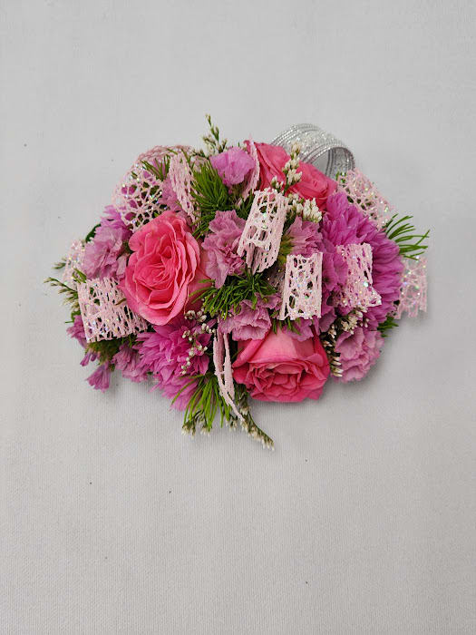 Barbie Wristlet Barbie Wristlet - Select this adorably pink corsage featuring spray roses, cornflower, statice, and misty. This wristlet corsage will come on a standard grey wristband that is elastic.