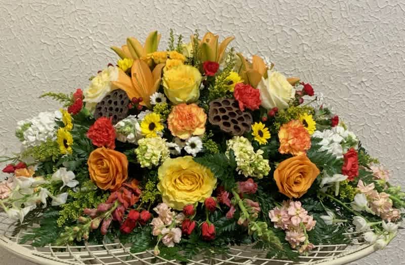 Western Sunset Casket Spray - Beautiful spray with roses, lillies, carnations, daisies, and greens to remember your loved one