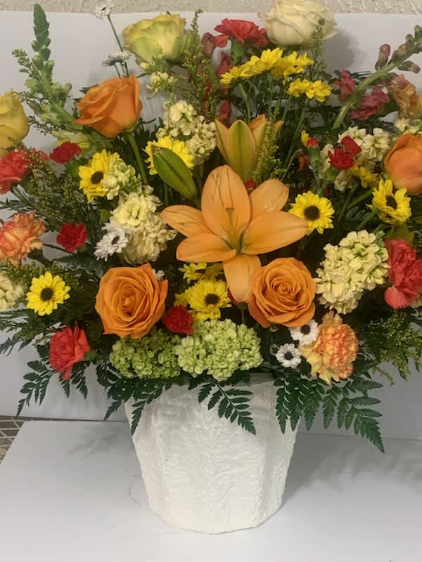 Western Sunset Bouquet - Magnificent sympathy floral arrangement that stuns and is perfect when a smaller arrangement just will not show how much we love you. 30&quot; tall with a large number of flowers of various kinds. Contains roses lilies, carnations, and other seasonal flowers  
