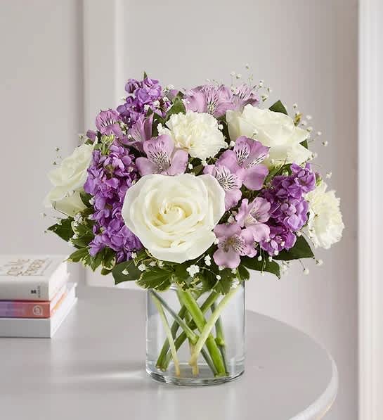 1-800 Flowers Lovely Lavender Medley™ - Lovely memories are made with thoughtful gifts for the ones we care about. Our charming lavender flower bouquet is loosely gathered with a medley of lavender &amp; white blooms. Hand-designed inside a clear cylinder vase with cascading greenery all around, it’s a wonderful way to express the sentiments you have inside your heart.  All-around arrangement with white roses and carnations; lavender Peruvian lilies (alstroemeria) and stock; accented with baby’s breath and assorted greenery Artistically designed a clear glass cylinder vase Extra large arrangement measures approximately 16&quot;H x 12&quot;H Large arrangement measures approximately 15&quot;H x 11&quot;W Medium arrangement measures approximately 13&quot;H x 10&quot;W Small arrangement measures approximately 12&quot;H x 9&quot;W Our florists select the freshest flowers available, so colors, varieties and container may vary due to local availability To ensure lasting beauty, Peruvian lilies may arrive in bud form and will fully bloom over the next few days
