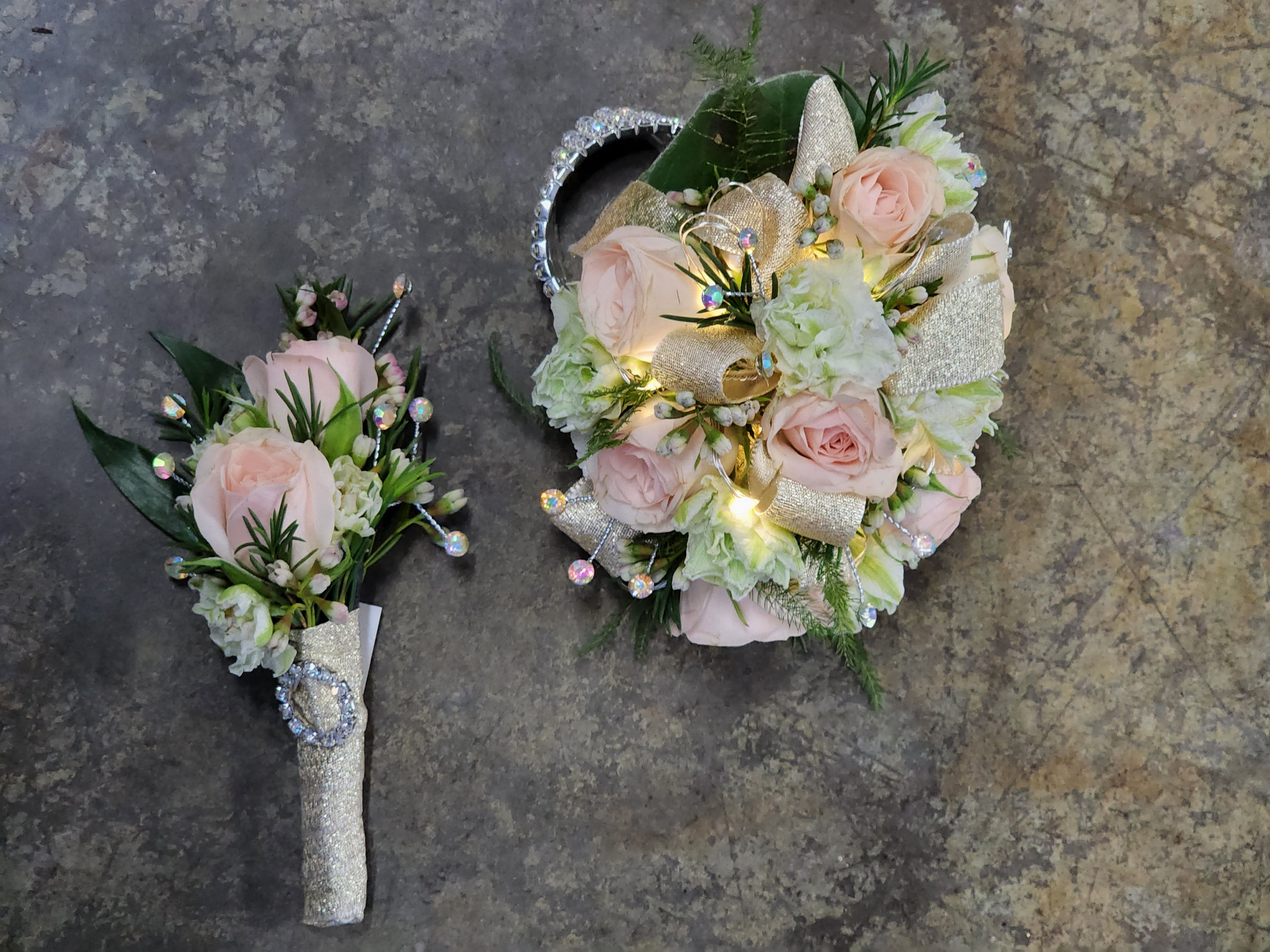 Festival of Lights Boutonniere And Wristlet Set - A wrist corsage and boutonniere set with light pink spray roses, white larkspur blooms, rhinestones and a sparkly keepsake bracelet. The corsage also features lights that turn on and brighten up the night.