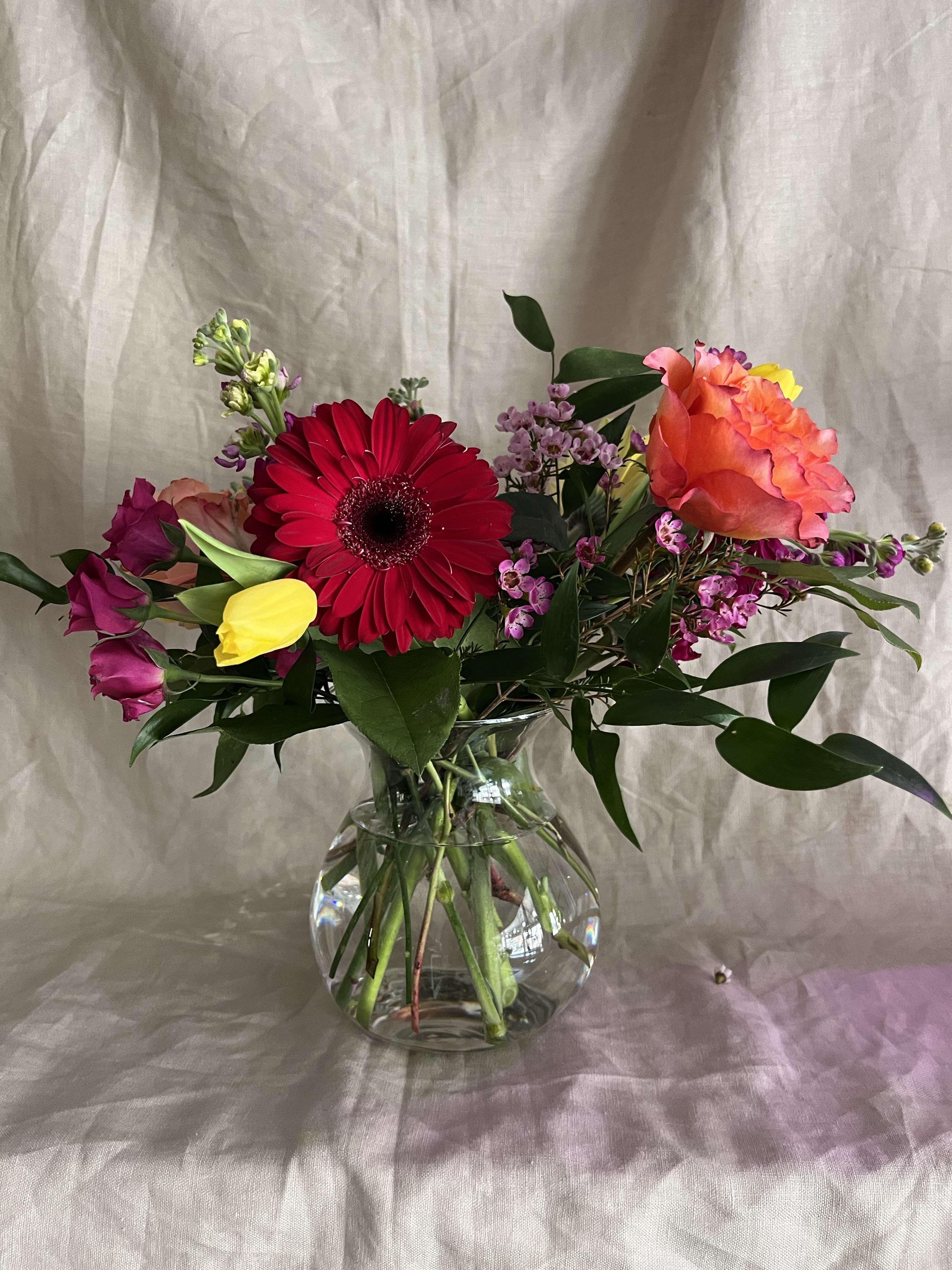 Vased Arrangement/ Everyday - An artfully styled assortment of the most beautiful flowers and greenery available to us, unique in both color and texture. Flower variety and color will vary weekly. All orders will be designed in a reusable vase/container.