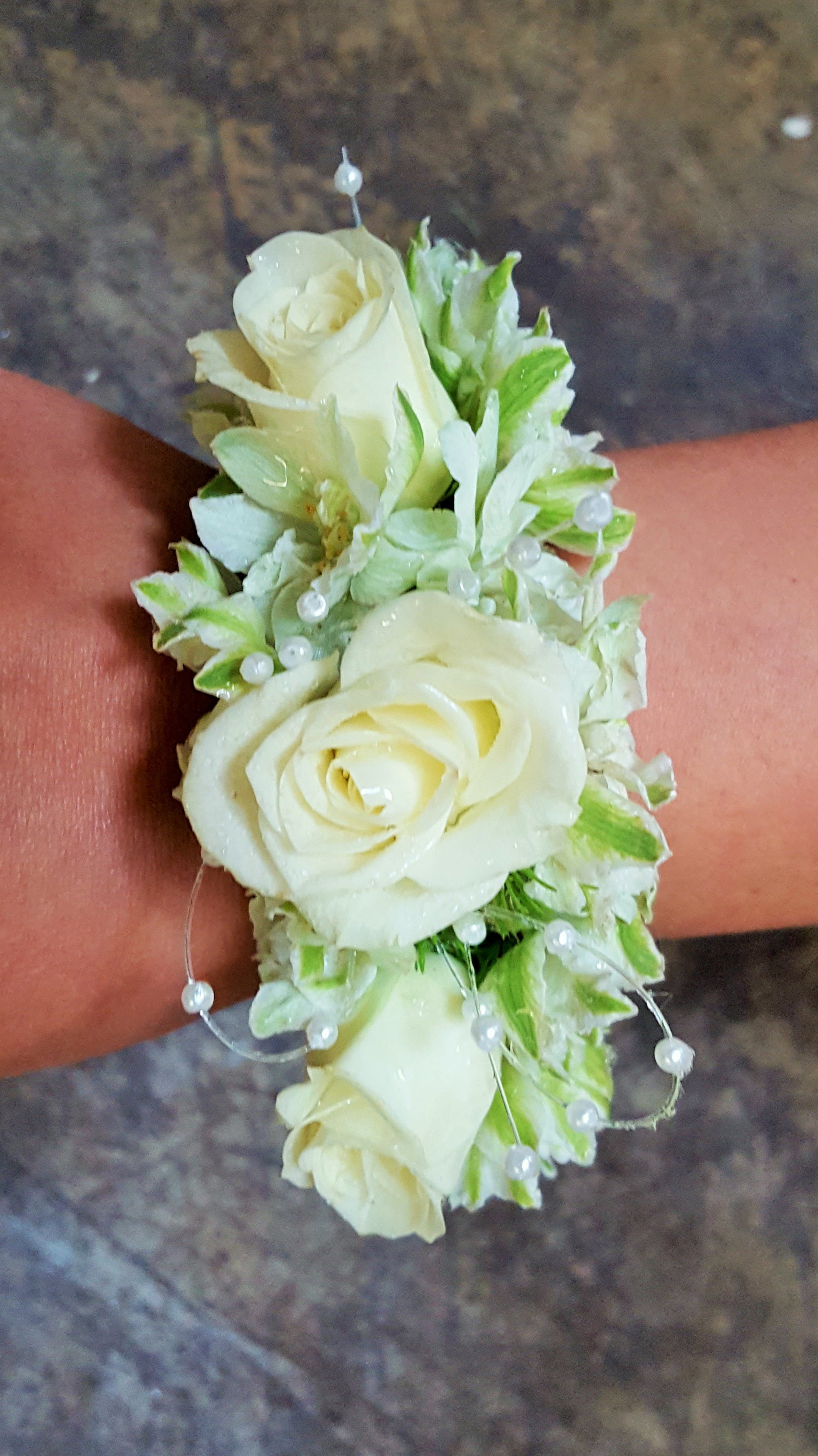 Lovely Wrist Cuff Lovely Wrist Cuff - Select this lovely and unique bracelet with white spray roses and white larkspur blooms and pearl accents. ALL PROM FLOWERS ARE AVAILABLE IN COLORS PICTURED OR A CUSTOM SELECTION. CHOOSE YOUR FLOWER COLORS, RIBBON COLOR AND ANY ADD ONS. FOR QUESTIONS CALL A FRIENDLY SALES REPRESENTATIVE AT STRELITZIA FLOWER CO.