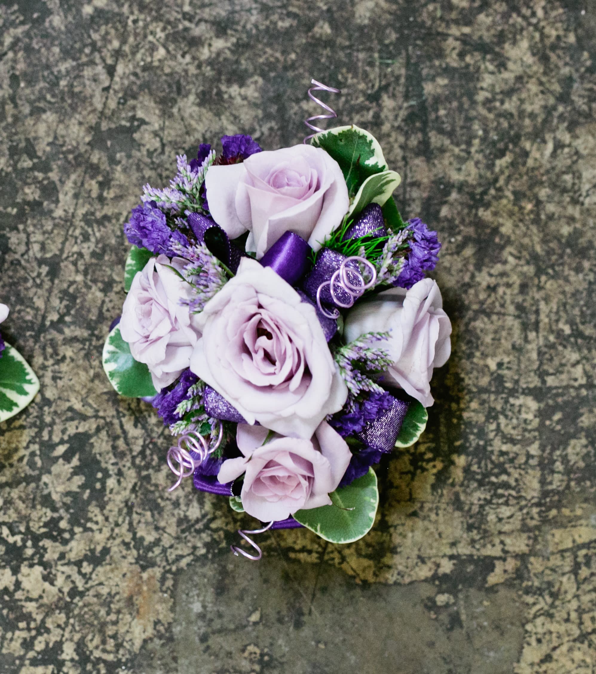 Rapunzel Wristlet Rapunzel Wristlet - Select this corsage consisting of lavender spray roses with lavender and purple accents. ALL PROM FLOWERS ARE AVAILABLE IN COLORS PICTURED OR A CUSTOM SELECTION. CHOOSE YOUR FLOWER COLORS, RIBBON COLOR AND ANY ADD ONS. FOR QUESTIONS CALL A FRIENDLY SALES REPRESENTATIVE AT STRELITZIA FLOWER CO.