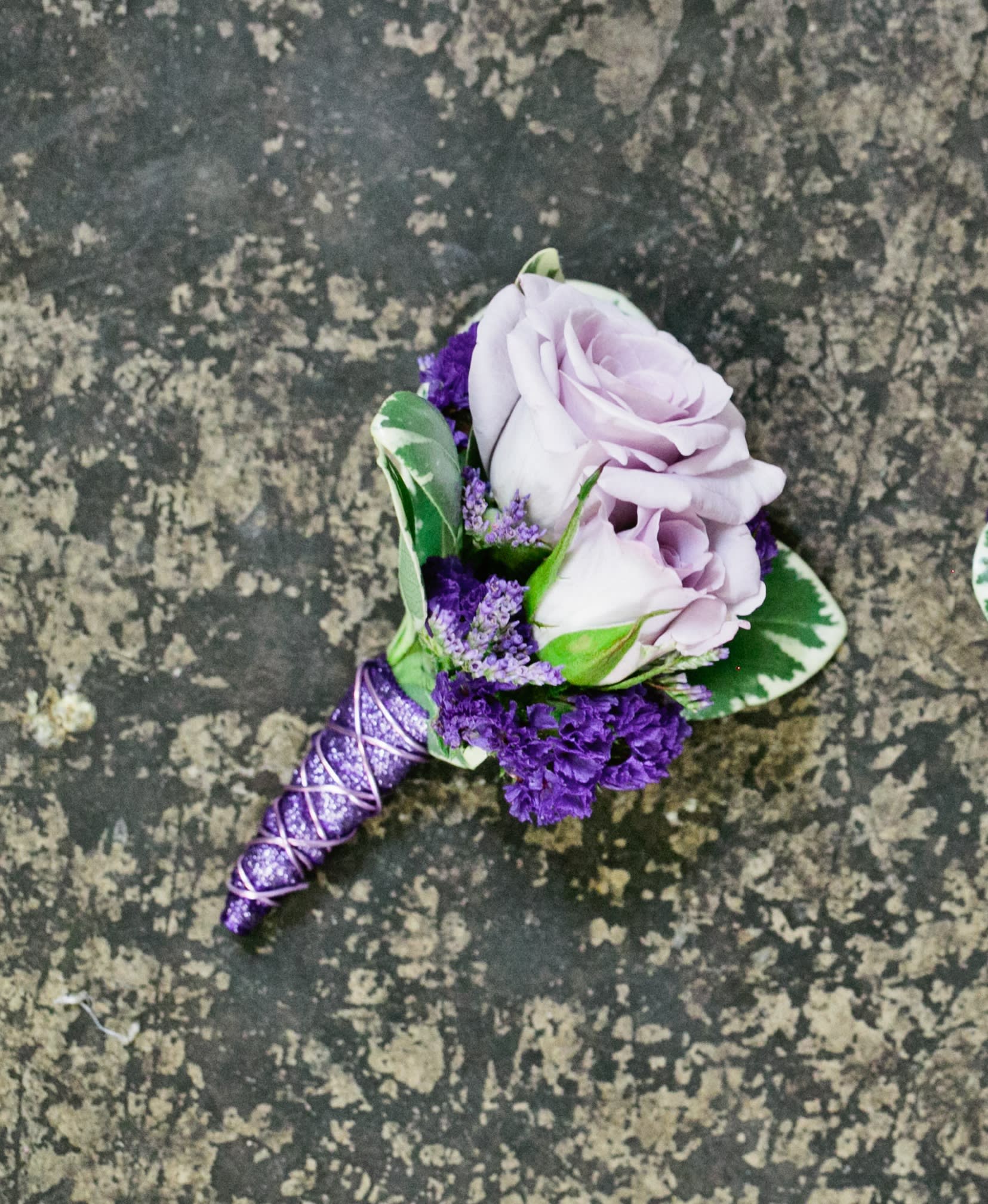 Rapunzel Boutonniere Rapunzel Boutonniere - Select this boutonniere with lavender spray roses and lavender accents. ALL PROM FLOWERS ARE AVAILABLE IN COLORS PICTURED OR A CUSTOM SELECTION. CHOOSE YOUR FLOWER COLORS, RIBBON COLOR AND ANY ADD ONS. FOR QUESTIONS CALL A FRIENDLY SALES REPRESENTATIVE AT STRELITZIA FLOWER CO.