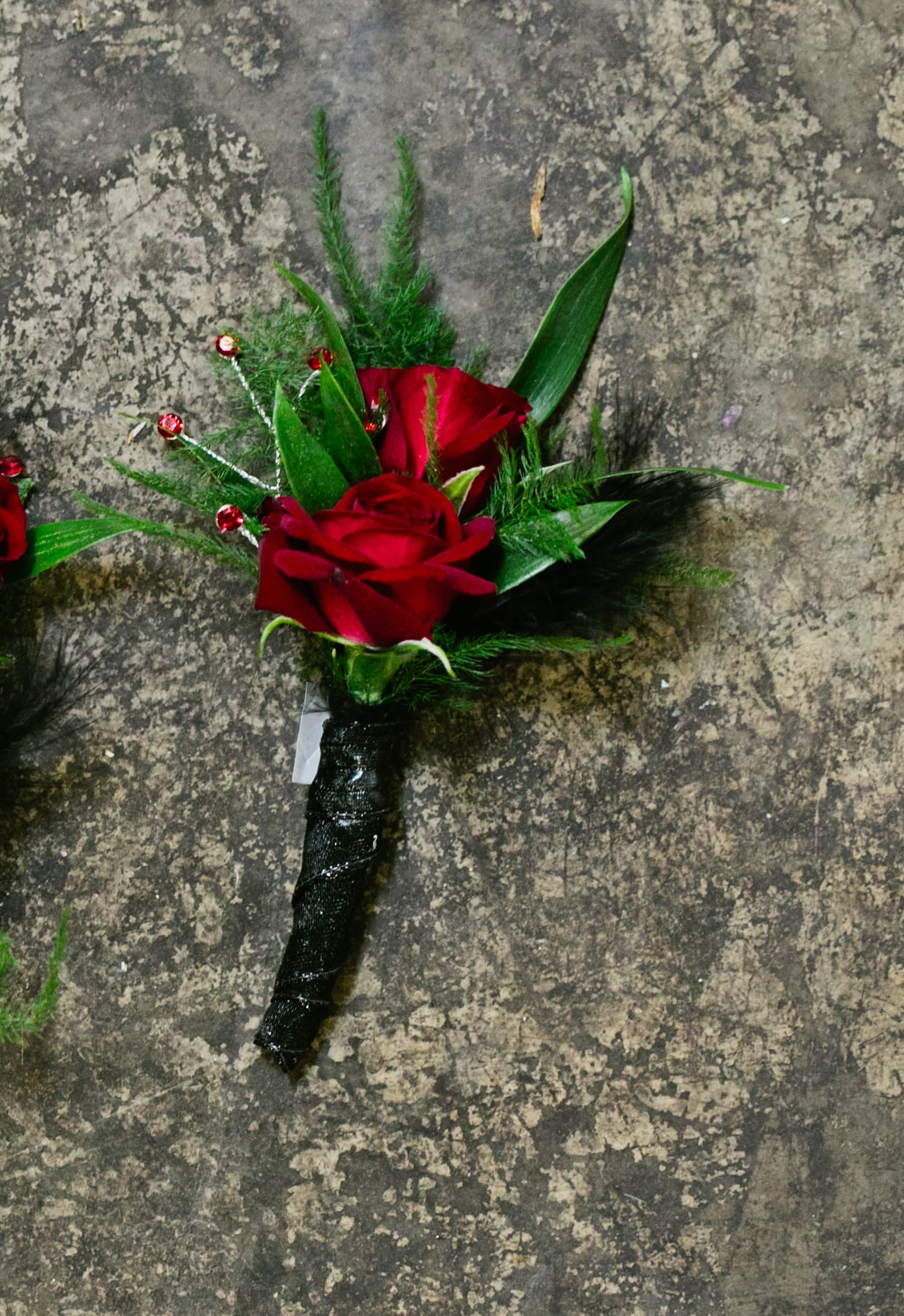 Witchcraft Boutonniere Witchcraft Boutonniere - Select this bewitching boutonniere of red spray roses accented with black ribbon and red rhinestones. ALL PROM FLOWERS ARE AVAILABLE IN COLORS PICTURED OR A CUSTOM SELECTION. CHOOSE YOUR FLOWER COLORS, RIBBON COLOR AND ANY ADD ONS. FOR QUESTIONS CALL A FRIENDLY SALES REPRESENTATIVE AT STRELITZIA FLOWER CO.