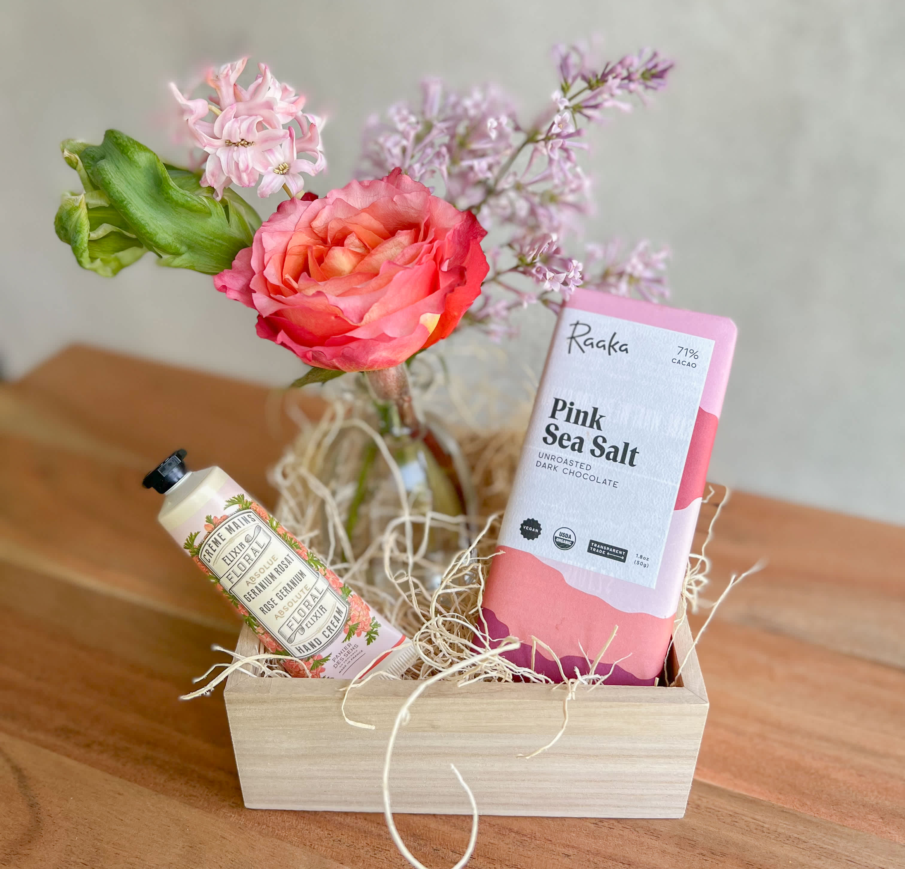 A Little Pick Me Up - A bud vase seasonal  arrangement paired with a hand cream by Panier Des Sens, a sea salt chocolate bar, a keepsake wooden box and a handwritten card. 