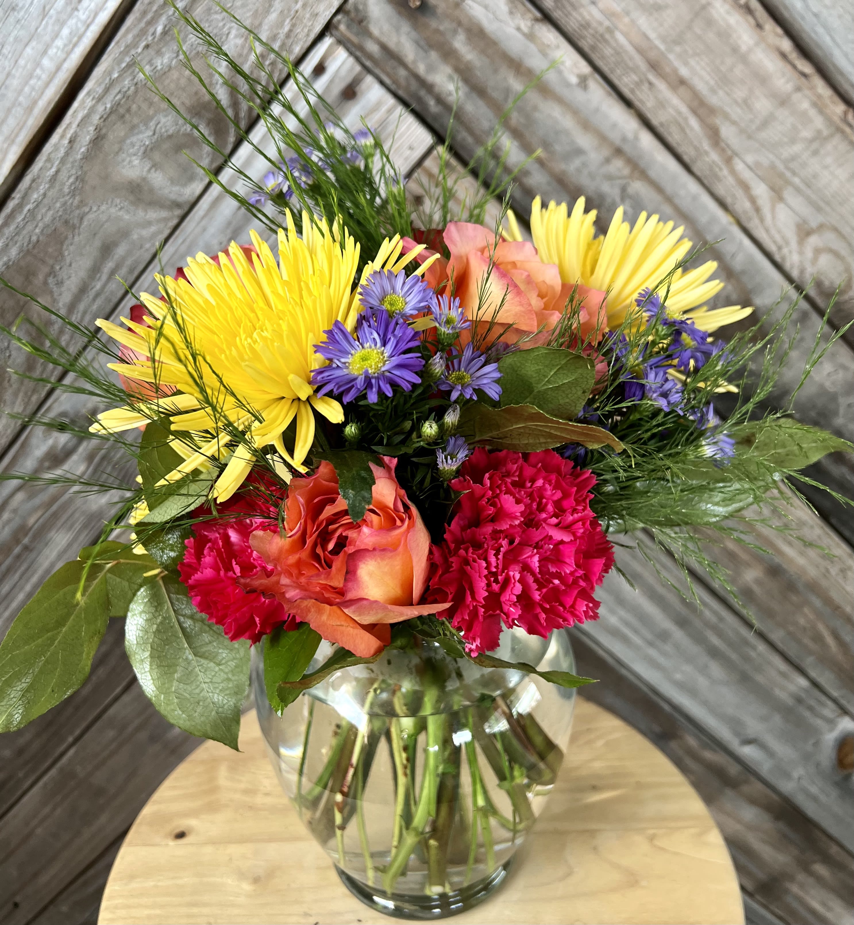 Bright Blooms Designer's Choice - Our vibrant &quot;Bright Blooms&quot; floral arrangement, designed to bring a burst of color and joy to your customers' lives. This lively arrangement features a captivating selection of bright and cheerful blooms that will instantly uplift any space and add a touch of exuberance to any occasion.