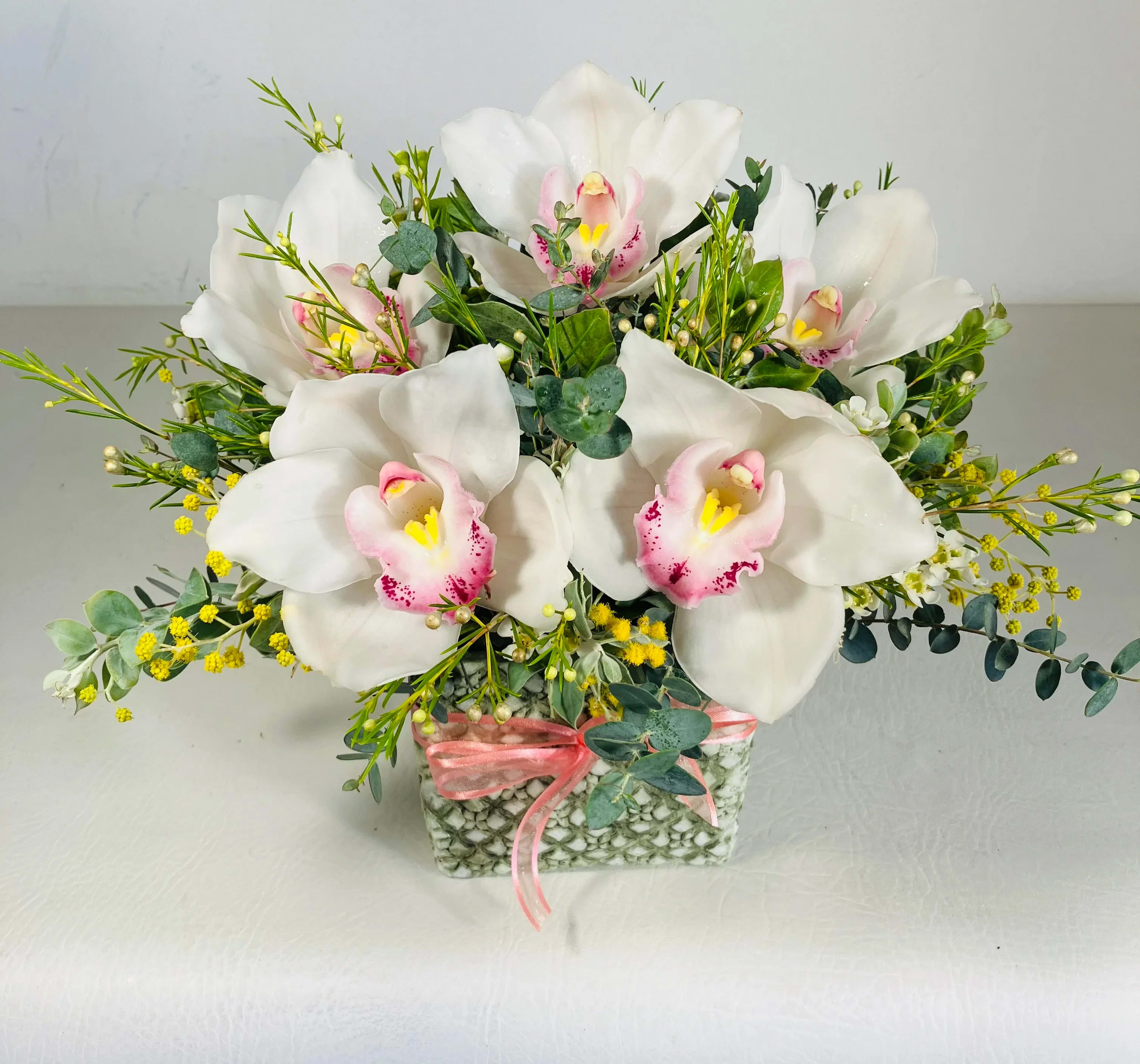 With Honor - An elegant arrangement of Cymbidium orchid to show honor and virtue for a loved one. This design is meant to show gratefulness, love, and respect for professional and familial relationships.  Can be made in a different colors of Cymbidium, Pink,Green,Yellow.