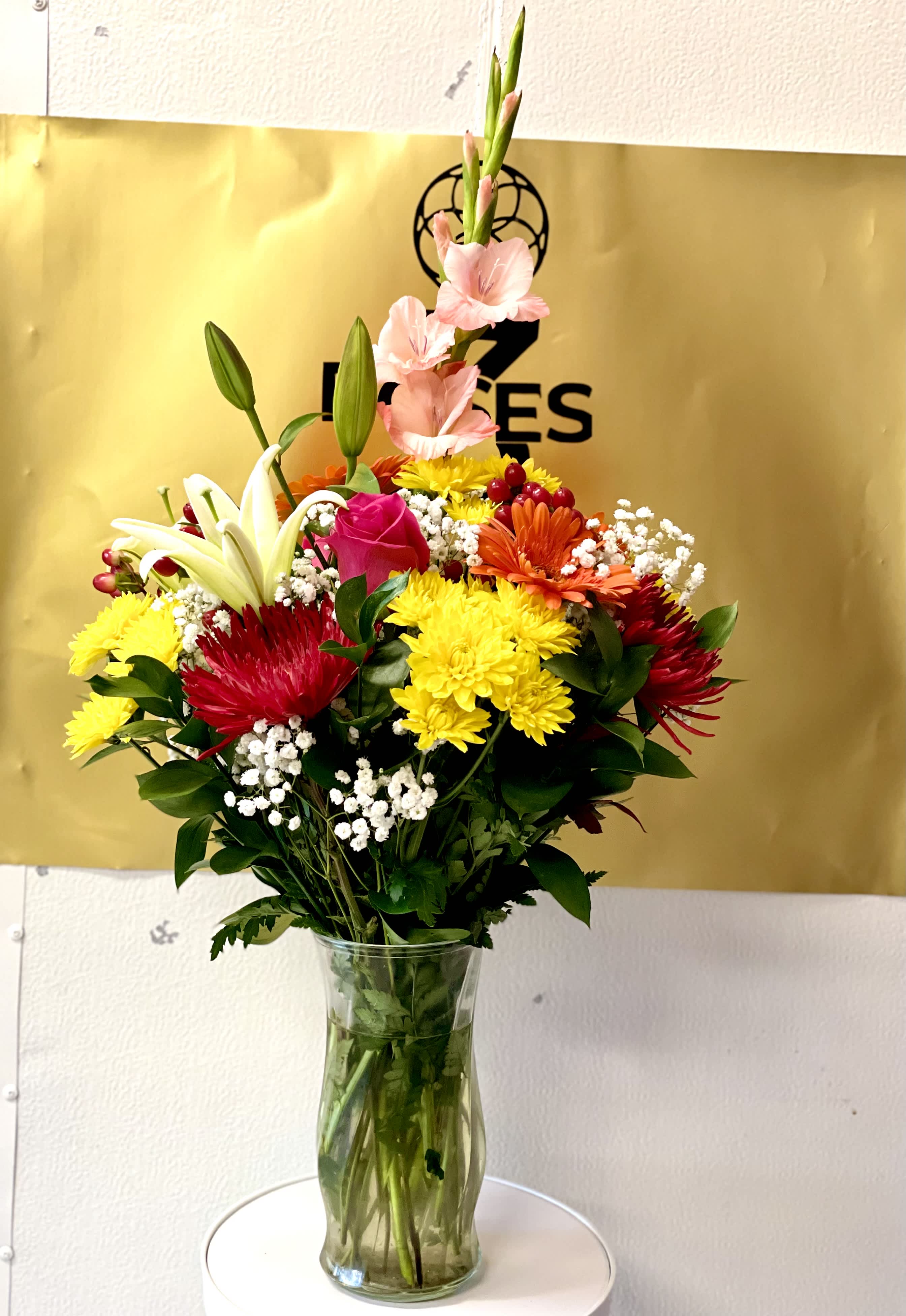 SPRING TIME ARRANGEMENT - This garden style arrangement includes gerbera daisies, roses, lilies, spiders, and . This is a great gift for a birthday or Mother's Day
