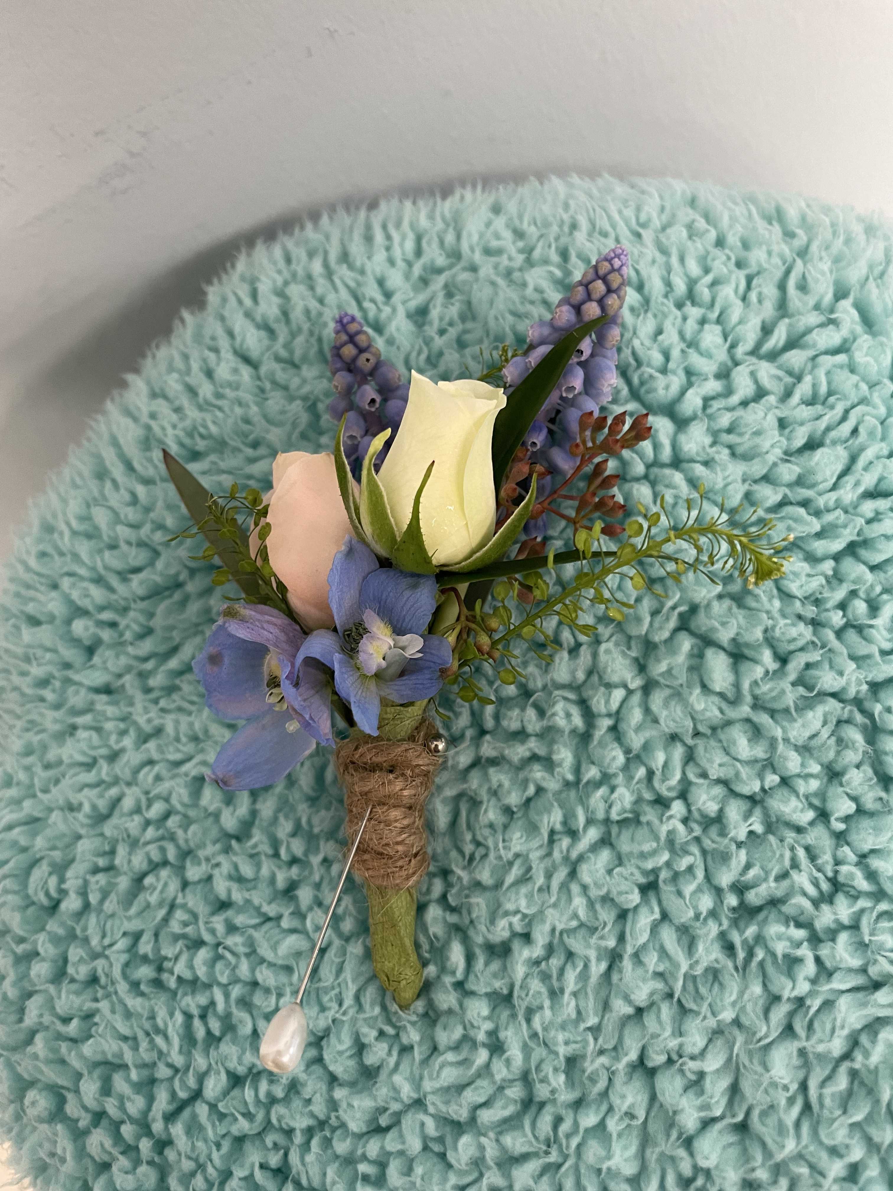Blue boutonniere Blue boutonniere - A blue boutonniere with a touch of pink and white. A perfect selection for prom, homecoming, and weddings. NOTE: **Flowers and colors can be changed UPON request**