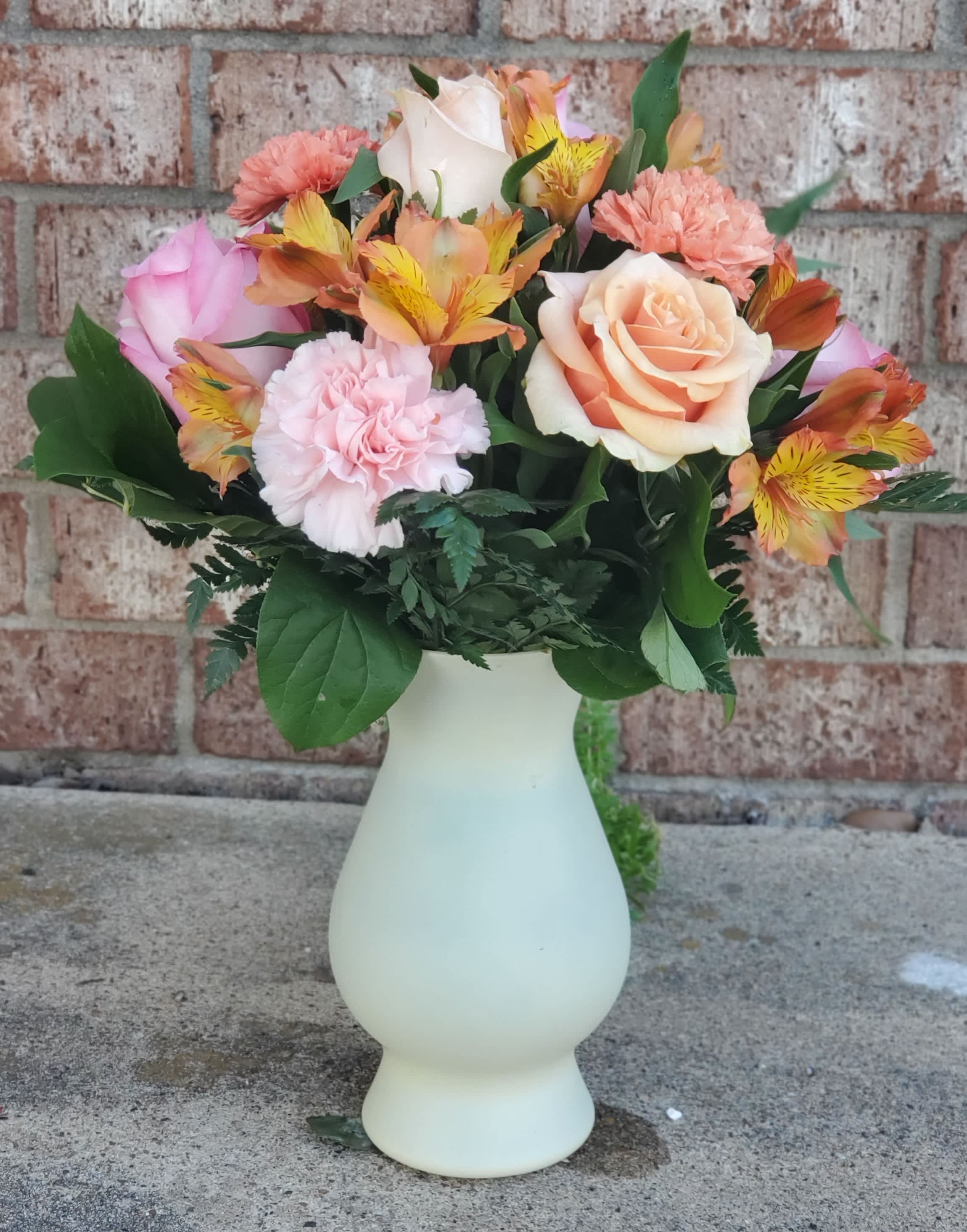 Texas Sunrise - You'll stay in your beloved's thoughts with this wonderful arrangement of sweet pinks and cheerful oranges. Featuring roses, carnations, and alstroemeria, this surprisingly simple arrangement makes a exciting statement!  Check out its accompanying design, the Texas Dreamin'!