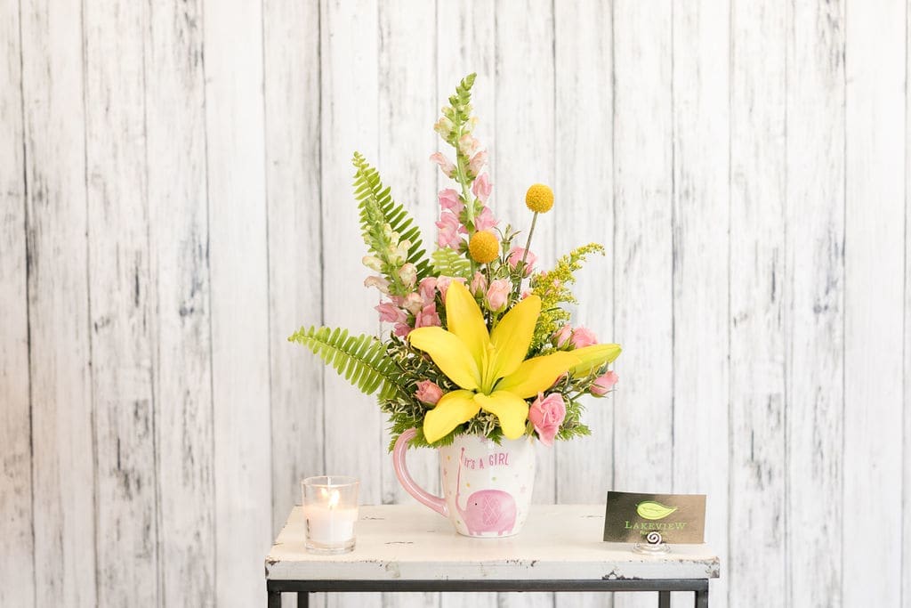 Hilda - Celebrate a special little person in your life with a pink and yellow arrangement of lilies, snapdragons and spray roses!  Approximate Dimensions: 16&quot; T X 9&quot; W