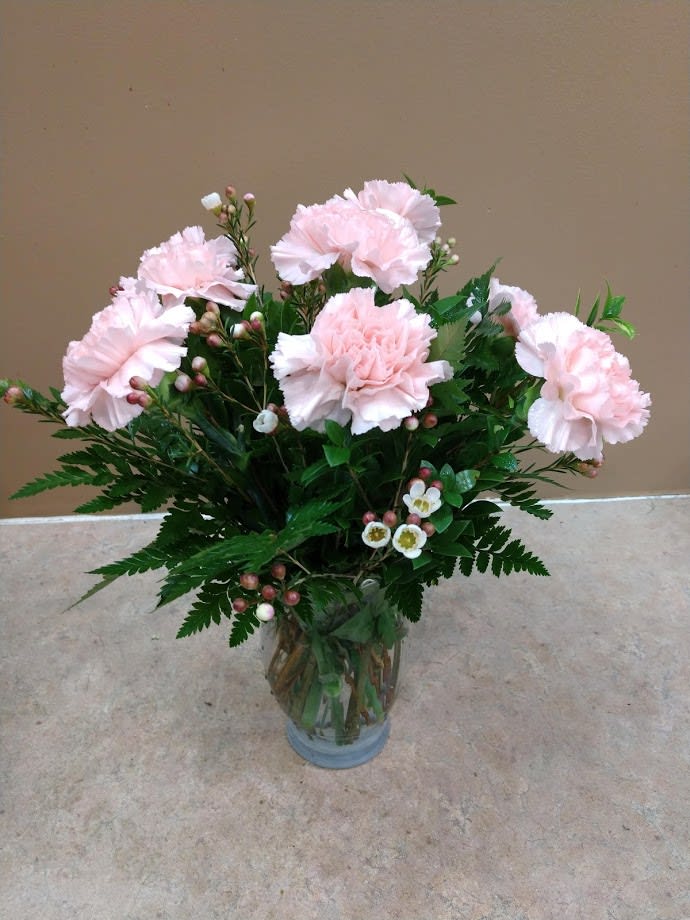 Pink Blush - A clear vase of pink carnations and mixed foliages. 