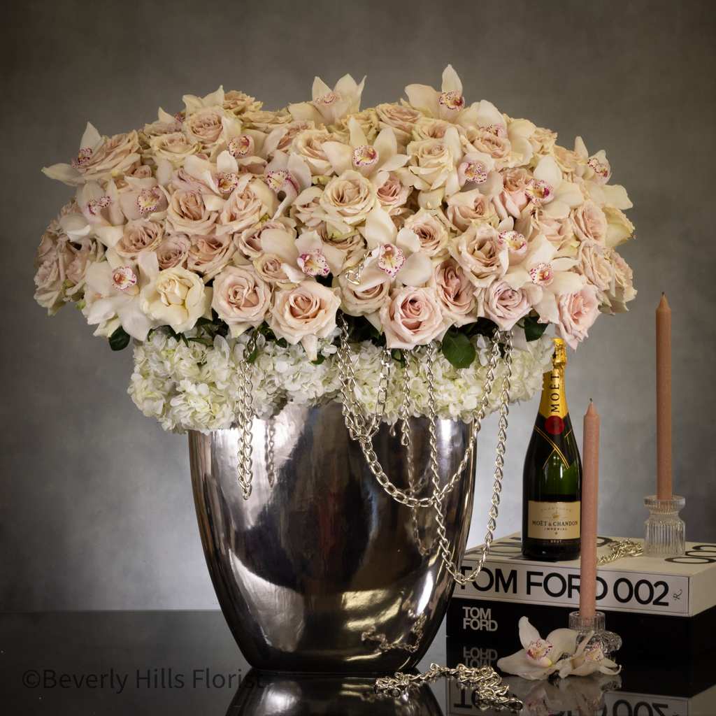Unchain my love - Sherman Oaks Florist Unchain my love - Sherman Oaks Florist - This luxurious bouquet boasts a stunning centerpiece of around 200 white roses and dozens of white cymbidium orchids, elegantly arranged on a bed of white hydrangeas in a tall silver vase. The addition of a delicate chain accent adds a touch of sophistication and charm, making this arrangement the perfect gift for your special someone on Valentine's Day. Experience the beauty and romance of this one-of-a-kind gift. Approx 48 inches tall