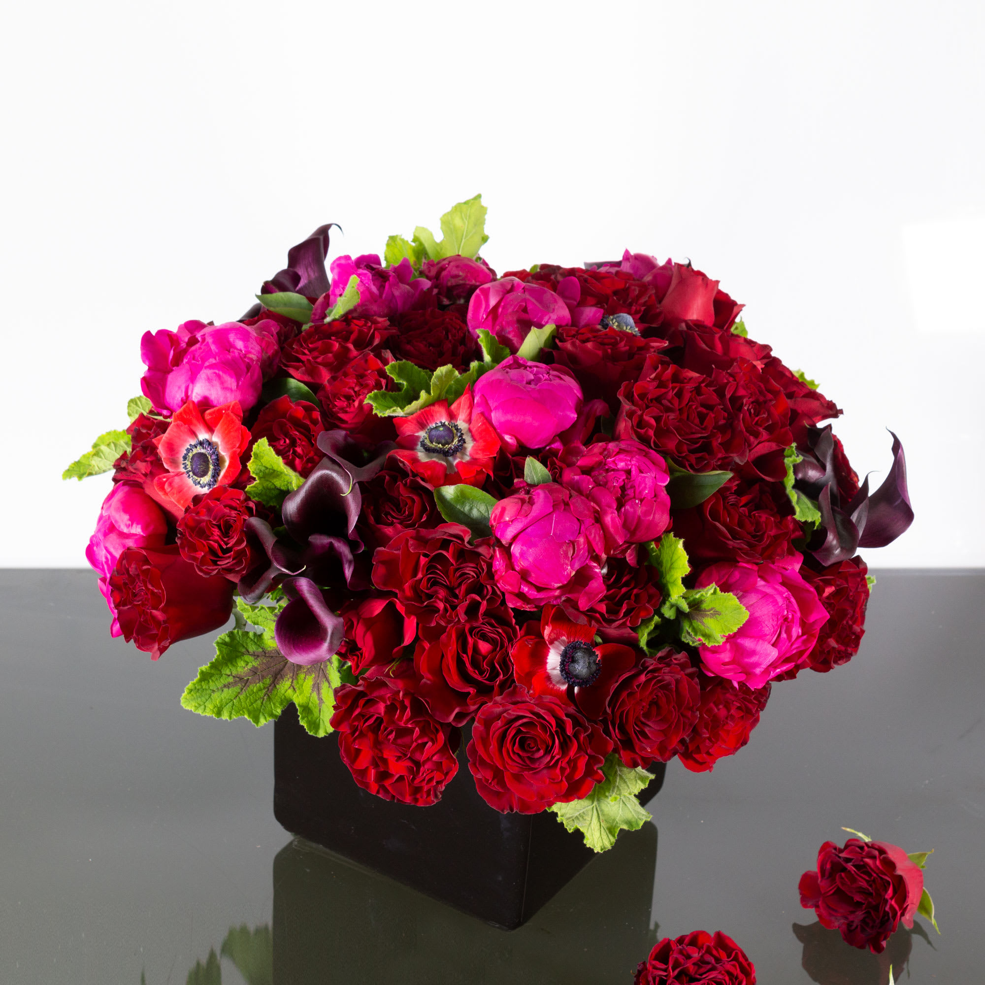Eternal Love - Sherman Oaks Florist - Charm the special person in your life with a jewel-toned gift of fresh blooms in brilliantly colorful shades of red, hot pink and dark purple. It's bright, bold and beautiful! This romantic bouquet of 50 red Roses, Midnight Garden Calla Lilies, hot pink Peonies and seasonal accents will beautifully express your sweetest sentiments. Approx: 24&quot; round  Standard: Includes 50 red roses as pictured  Deluxe: Includes 100 red roses  Premium: Includes 200 red roses
