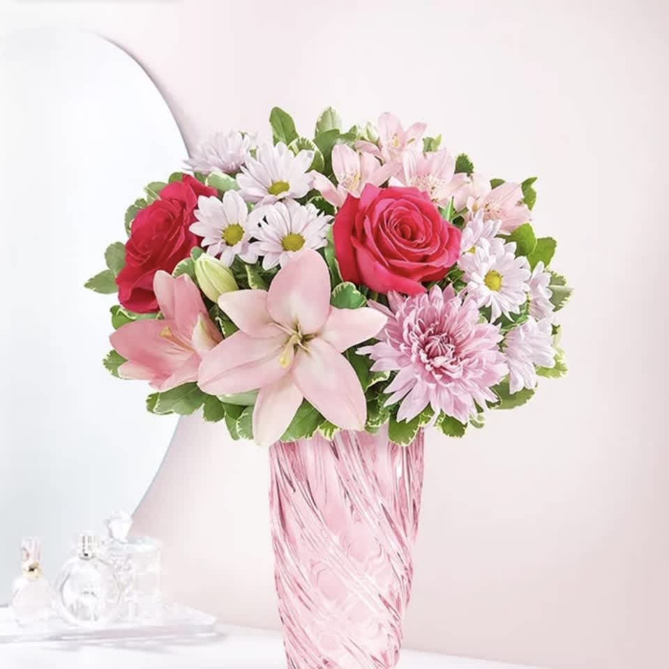 191322 Mother's Embrace - Thank Mom for a lifetime of hugs with our beautiful bouquet. A mix of blooms in shades of pink and lavender is designed in our keepsake vase with a spiral design, celebrating the beauty of Depression era pressed glass. 