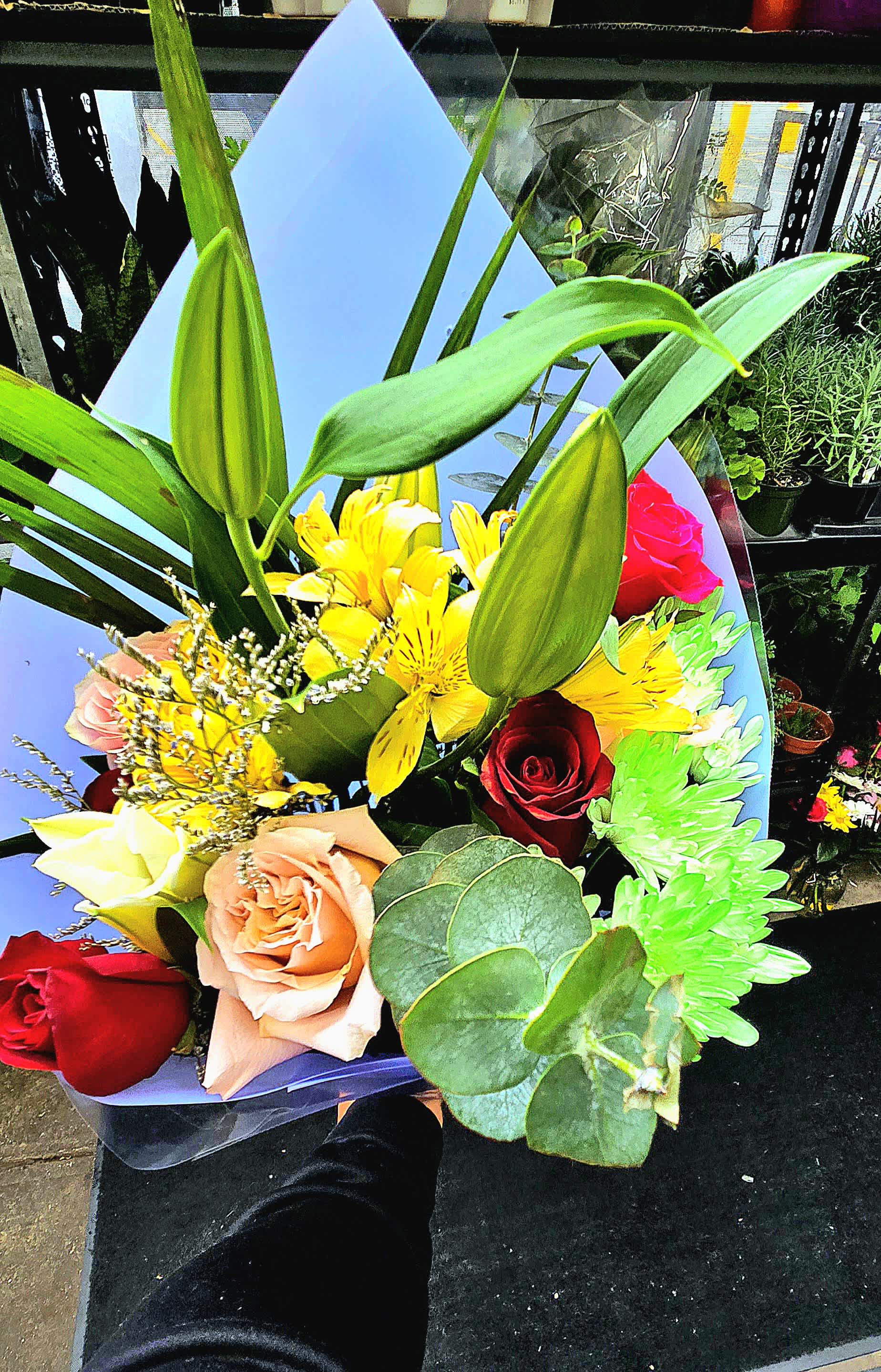 Bouquet #6 - it is made with: 1 white lily 7 roses 3 pompones 2 alstroemeria 1 gasphya  green eucalyptus wrapped with blue paper and clear plastic
