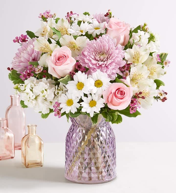 Marvelous Mom™ - Our sweet bouquet of roses, lilies and daisy poms is gathered in our keepsake lavender-colored vase