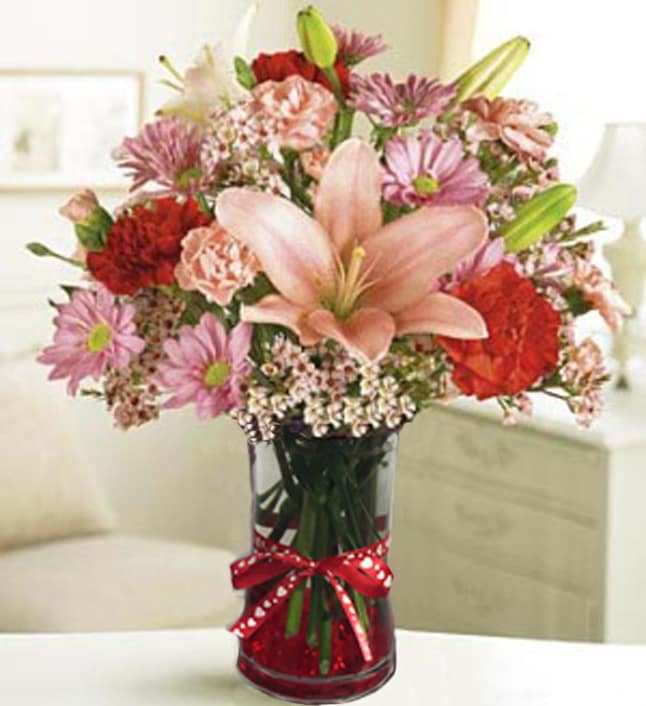 Mom's Expression - M25 - Send this exquisite arrangement of carnations, lilies and more to express your feelings loud and clear for that special someone! A terrific gift for any occasion, at a fantastic value you'll love! Carnations, Asiatic lilies, daisy poms, waxflower and salal, artistically designed by our select florists Arranged in a clear gathering glass vase; measures 6.8&quot;H Components may vary Arrangement measures approximately 15&quot;H x 12&quot;D What's The Story?One of the hardiest of all flowers, the carnation is a lasting symbol of love, fascination and distinction.