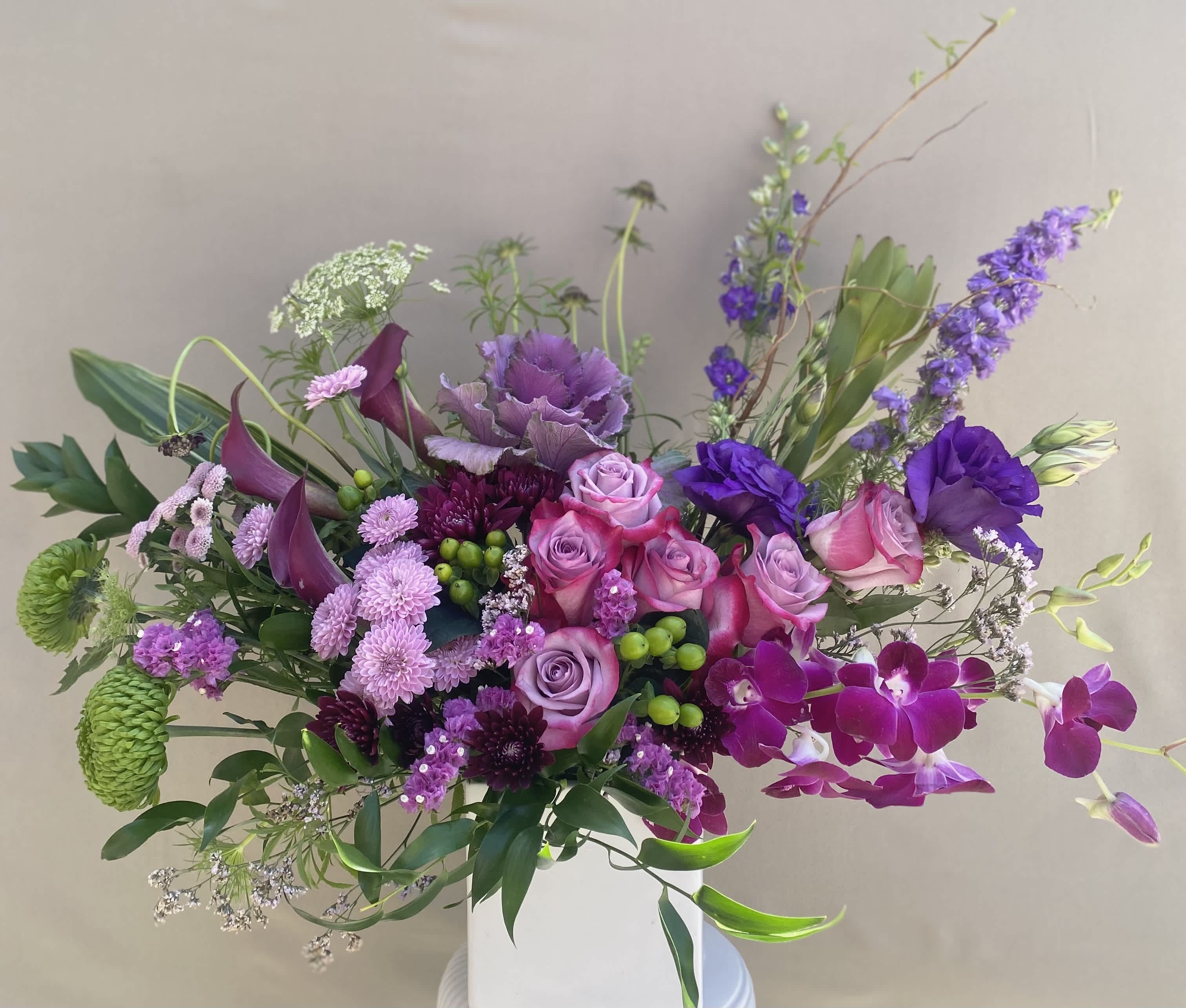 Violette Violette - For the purple lover in your life. Includes roses, lisianthus, calla lilies, dendrobium orchids, larkspur, kale, and much more arranged in a vase