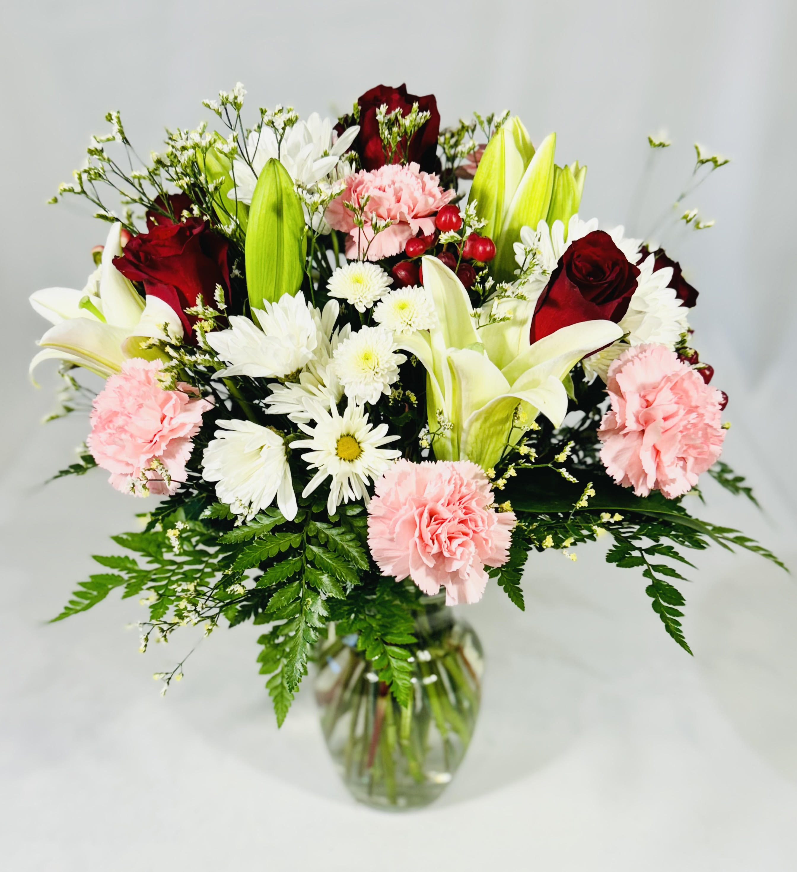 Timeless Elegance  - Get this Gorgeous Mix of White Lilies, Pink Carnations, Red Roses, White Buttons, White Daisies, Limonium and lush greenery. Stunning arrangement for any occasion! 