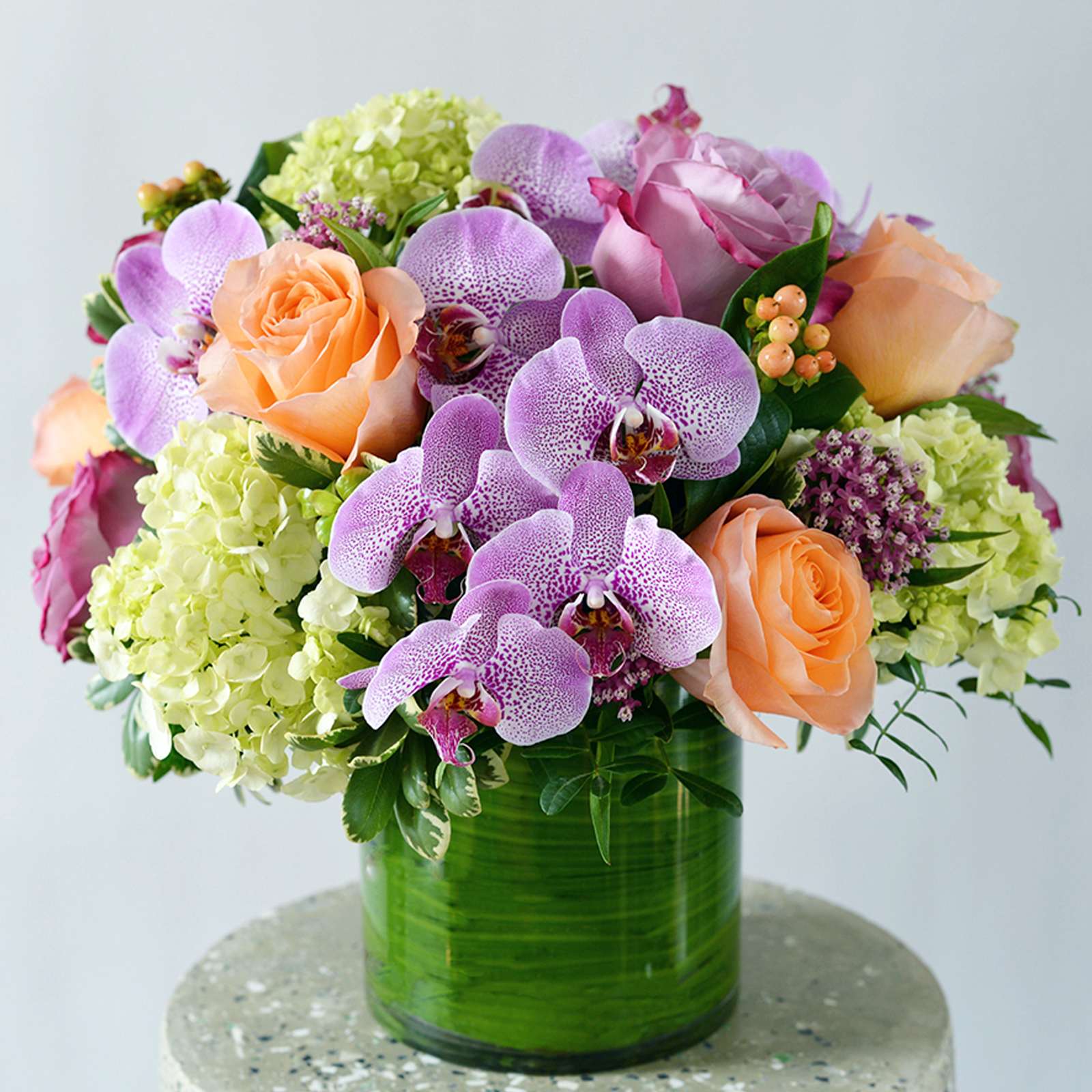 Radiant Joy Bouquet - Brimming with soft hues and gentle tones, this bouquet captures the essence of serenity with pastel-colored roses, carnations, and hydrangeas. Arranged delicately in a graceful glass vase, it offers a tranquil and elegant touch to any space.