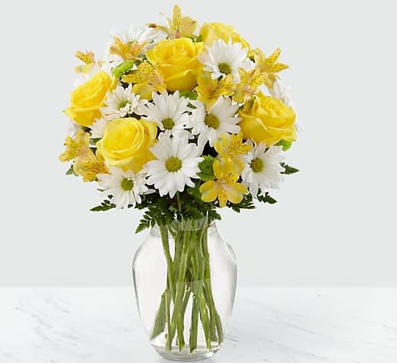 Sunny Sentiments Bouquet     - The Sunny Sentiments is a blooming expression of cheer. Yellow roses share the spotlight with traditional daisies, alstroemeria, and green button poms to create a memorable bouquet. Accented with lush greens and arranged in a classic clear glass vase, this bouquet is a wonderful way to celebrate any of life's special moments. 