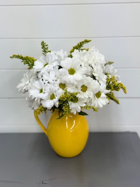 Sunny Day Pitcher of Daisies - A pitcher of white daisies with yellow solidago. Deluxe has yellow spray roses. Colors and flowers are subject to change due to availability. As Shown : FCT139-1A   T139-1Aa