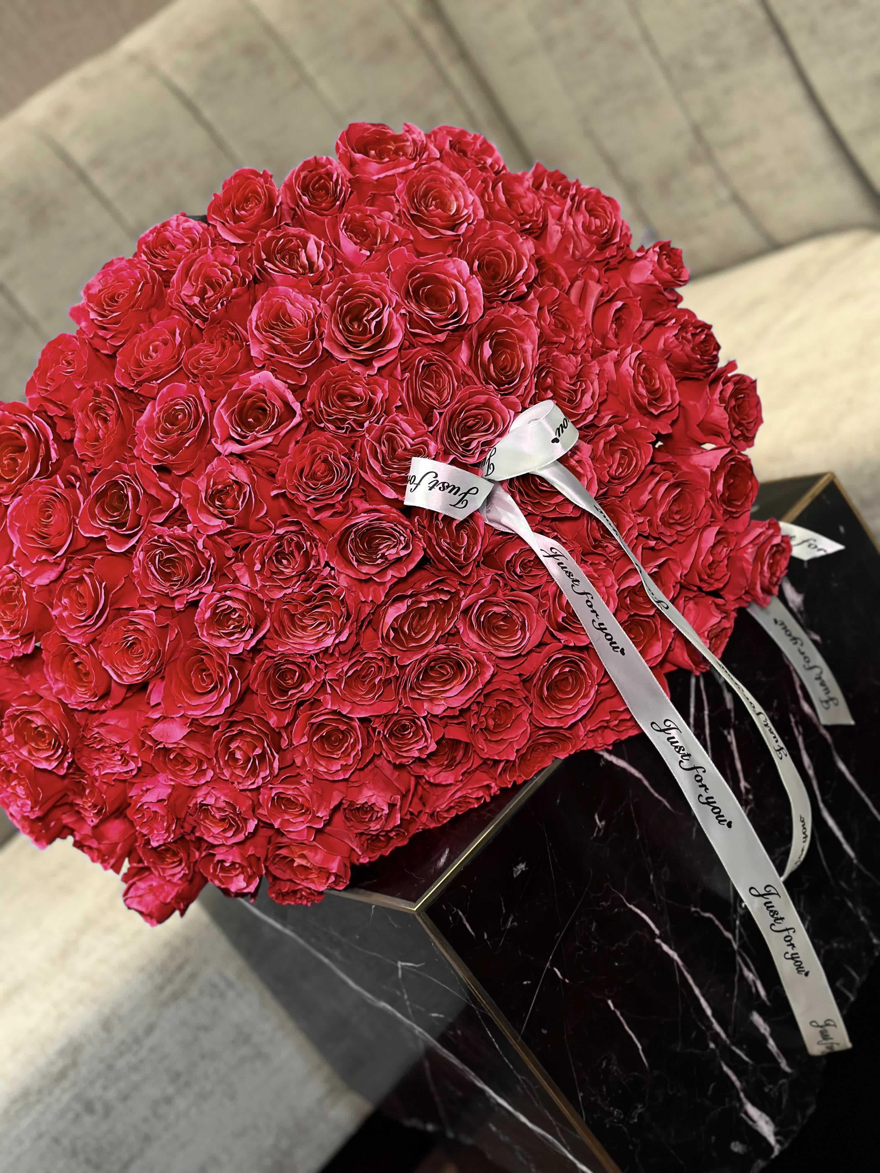 100 Red Roses - Bouquet  of 100 red roses, each petal a vibrant testament to passion and romance. Their velvety texture invites a gentle caress, while their intoxicating fragrance fills the air with an aura of love and desire. With every glance, these majestic blooms captivate the soul, evoking feelings of admiration and adoration. Whether celebrating a grand occasion or simply expressing heartfelt sentiments, this magnificent ensemble of red roses serves as an unforgettable declaration of love and affection.