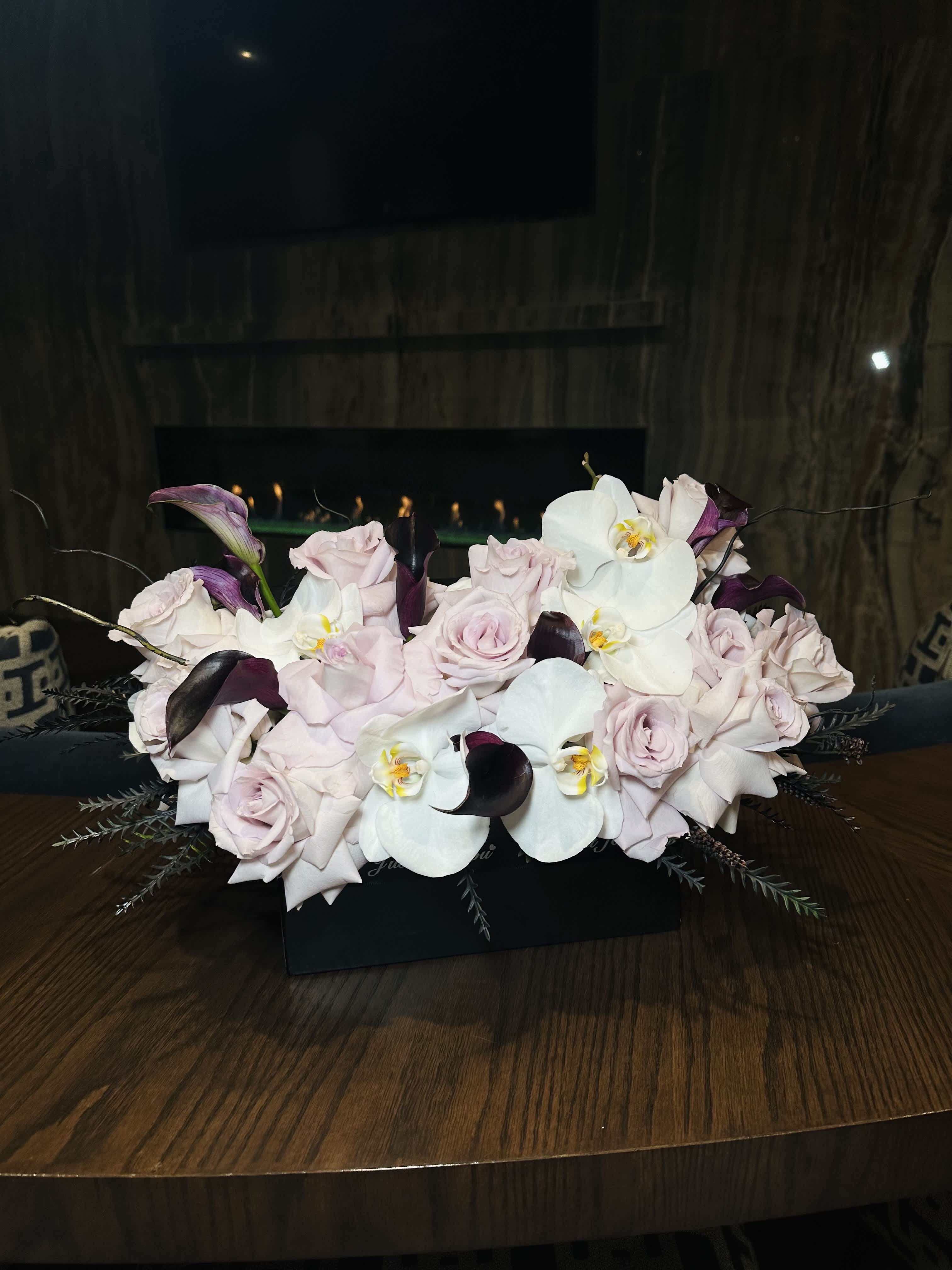 Blueberry Night - A composition in a black box with roses, calla lilies, and orchids exudes sophistication and elegance. The striking contrast of the black box enhances the vibrant colors of the flowers. The roses, with their romantic allure, serve as the focal point, while the graceful calla lilies add a touch of refinement. The delicate orchids bring an exotic and luxurious element to the arrangement, creating a captivating visual display. This composition is perfect for adding a luxurious and stylish accent to any space or occasion. 