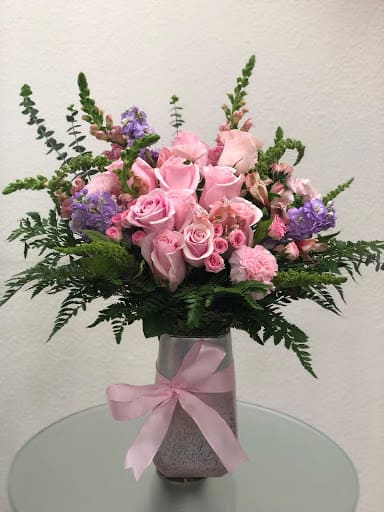 FLOR PALIDA (PALE FLOWER) .4 - &quot;Lovely lady with this feminine bouquet of pastel and pink flowers. The pretty pink arrangement is a heartfelt choice. Name after someone’s favorite love song  A feminine mix of pink roses, pink spray roses, pink snap dragons and light purple stocks, green filler on season, pink Alstromeiras. Garnished with leather fern are presented in a charming pink stone vase. SET: All-Around&quot;
