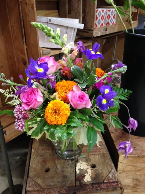 bright and colorful summer vase  - marigolds blue iris and hot pink roses with accents 