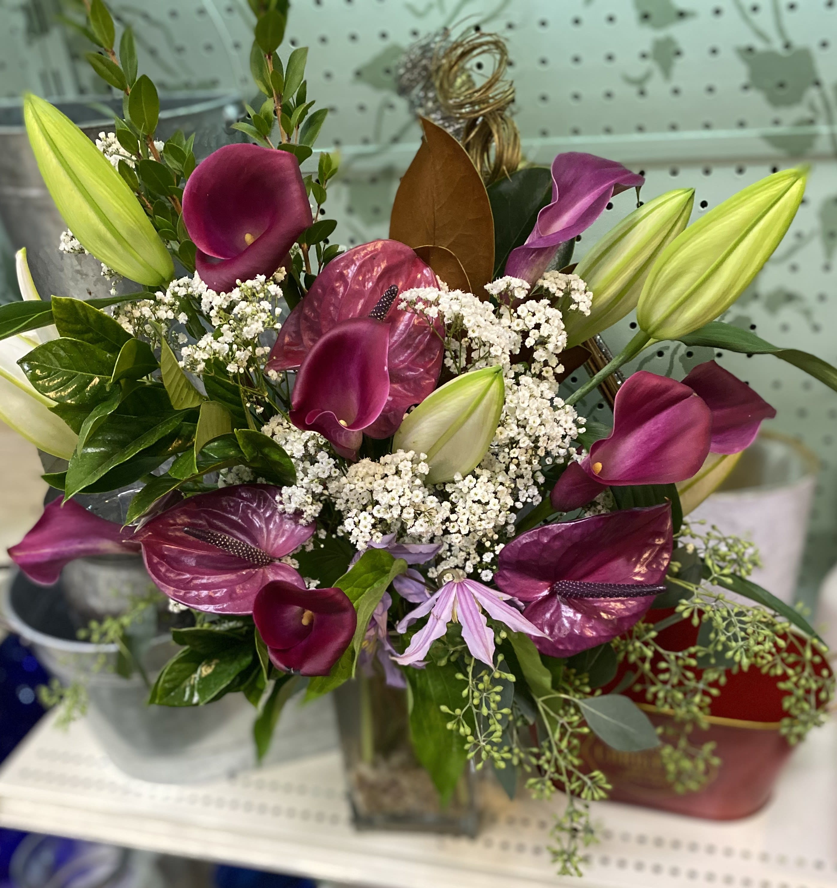 Lilly overload  - This vase arrangement is made up of lilies, peace lilies, and calla lilies in a glass vase. 