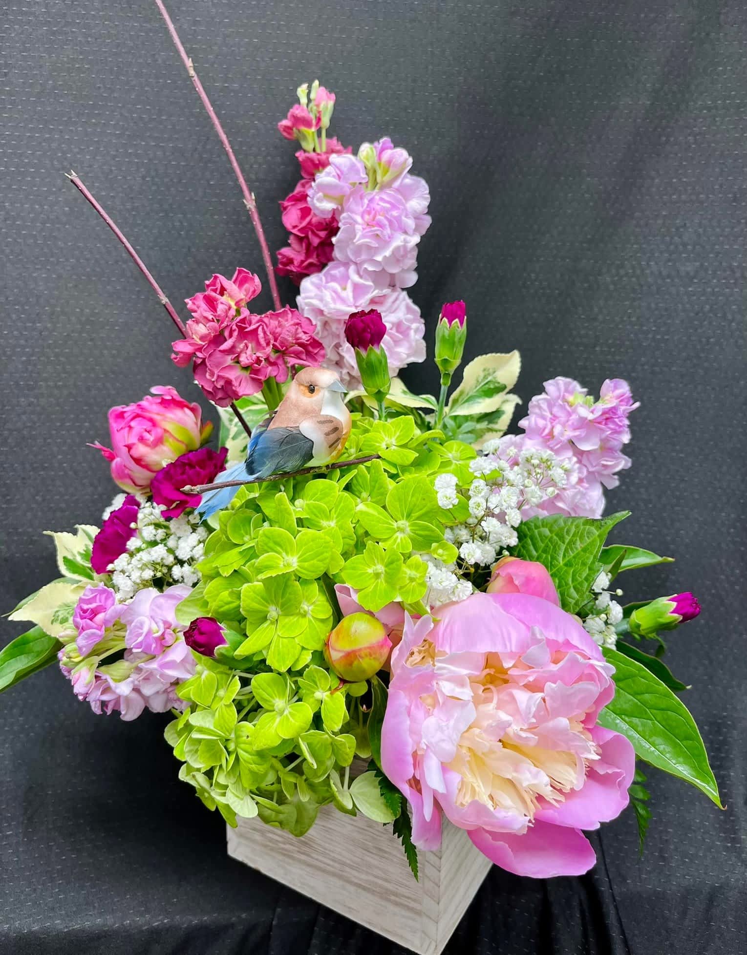 Pretty in Pink! - This bright colorful arrangement will brighten anyone's day! This arrangement includes bright pinks with stock, peony, hydrangea, in a wooden box. 