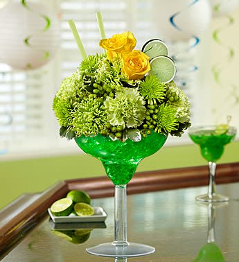 Margarita Bouquet - EXCLUSIVE Toast that special occasion in style -- send our truly original lime margarita arrangement. Mixed with yellow roses, green carnations, green spider mums, poms and hypericum, this fresh floral cocktail is hand-arranged in an oversized acrylic margarita glass. Accented with realistic green lime slices and green straws, it's an unforgettable gift that will keep the party going. Stylish arrangement of roses, carnations, poms, spider mums, hypericum and variegated pittosporum Hand-designed by our florists in a 10&quot;H oversized acrylic margarita glass Accented with straws and green lime slice picks Extra Large approximately 13&quot;H x 8&quot;L Small arrangement does not include hypericum or carnations and measures approximately 12.5&quot;H x 7&quot;L Our florists select the freshest flowers available so colors and varieties may vary