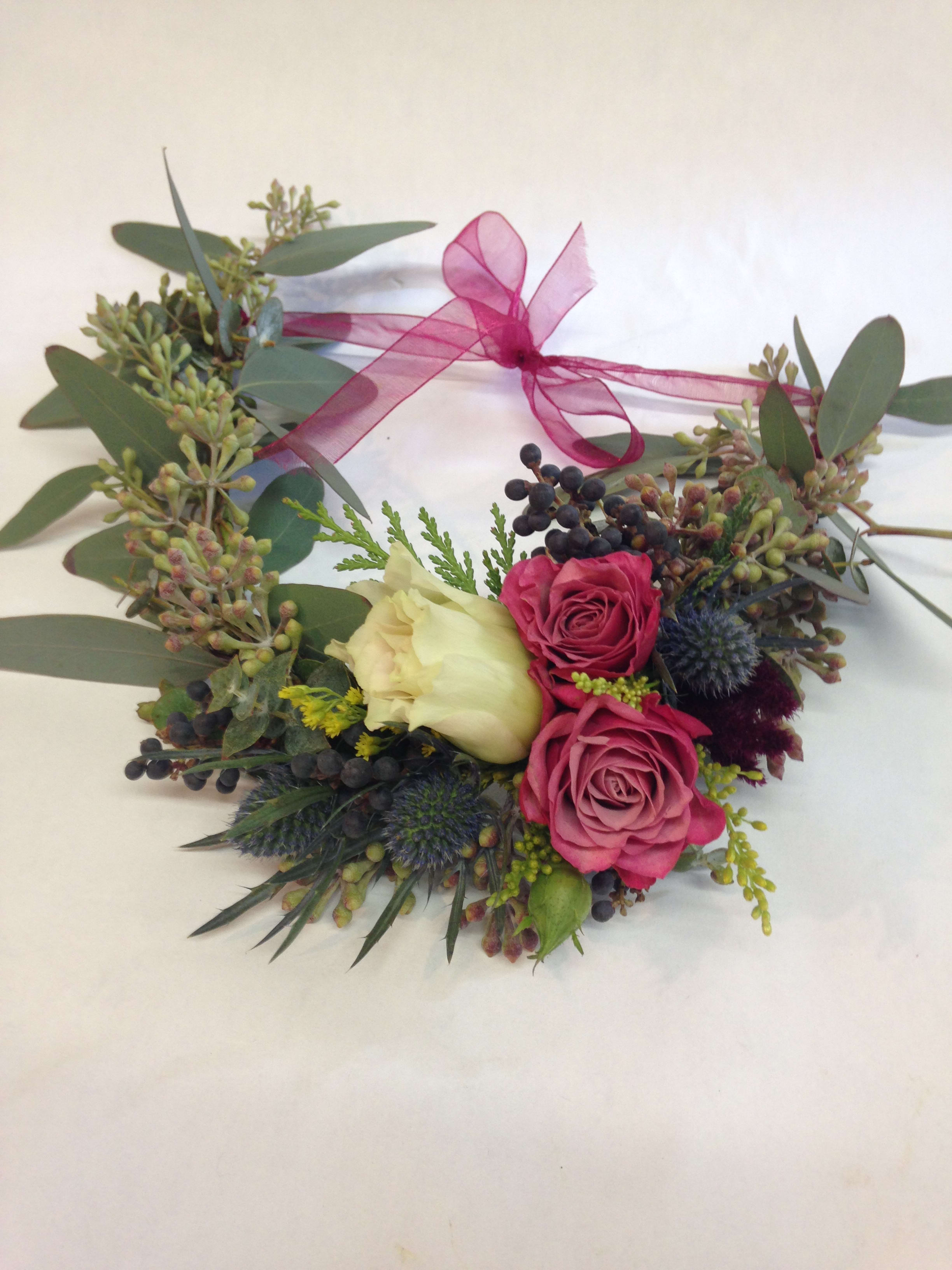 Asymmetrical Sweetie Flower Crown Asymmetrical Sweetie Flower Crown - A fun and textured flower crown bursting with personality. Featuring spray roses, thistle, seeded eucalyptus and other filler,
