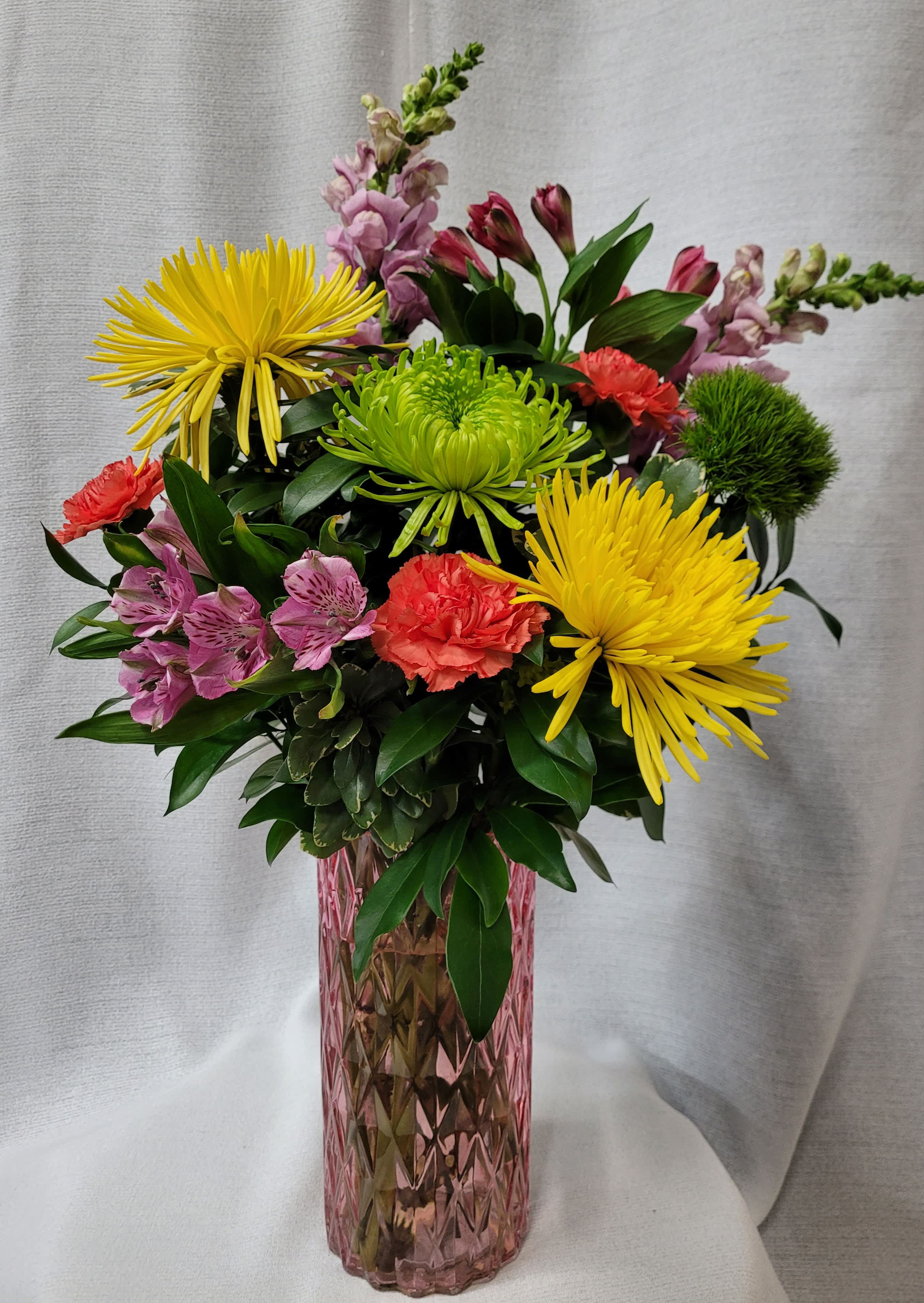 Happy Day - A tall cut pink vase filled with carnations, mums, dianthus, snap dragons, and alstromeria.