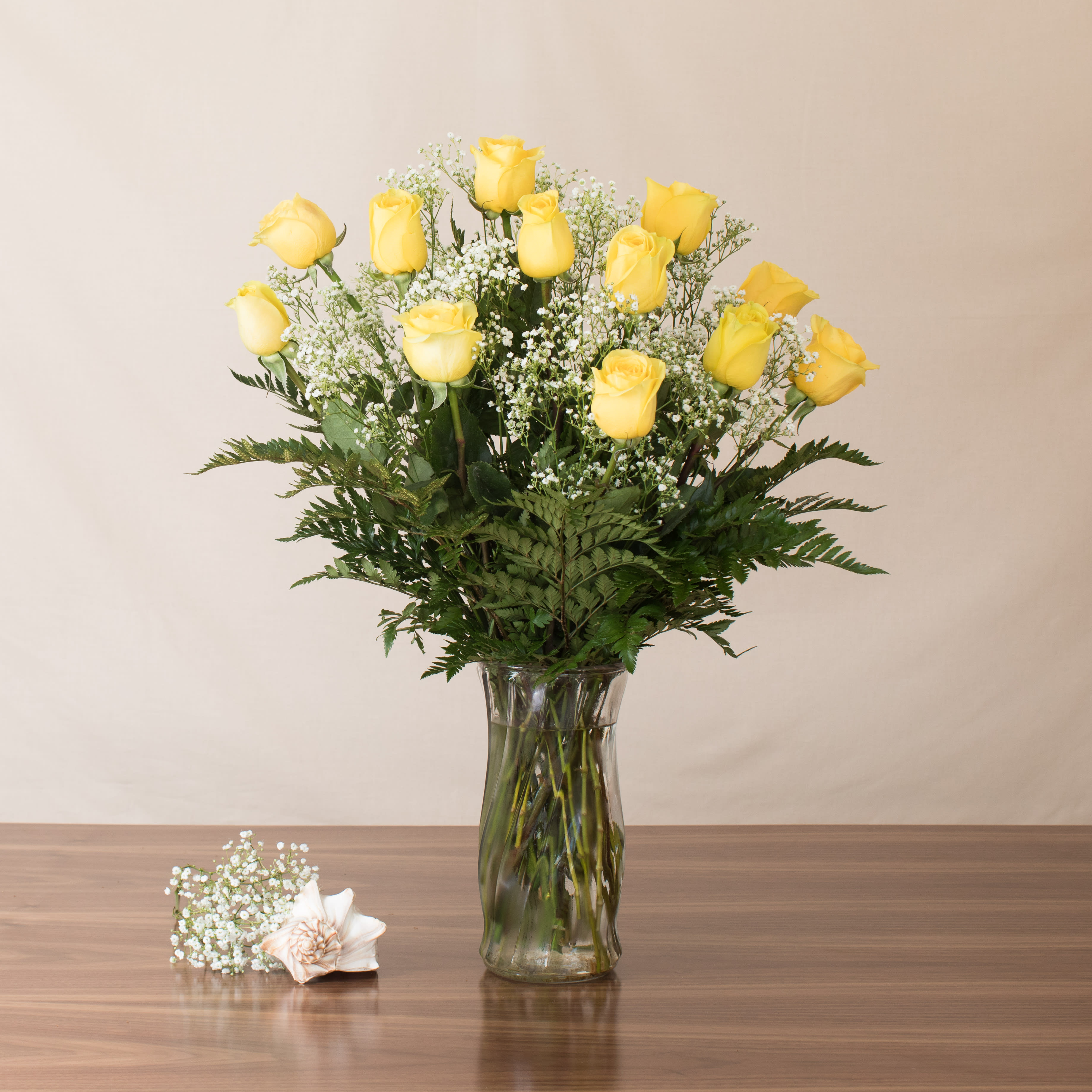 Watanabe Yellow Rose Masterpiece - Brighten up the day of your special someone with a dozen of these Yellow long stem roses, with accent greens, served in a beautiful glass vase!