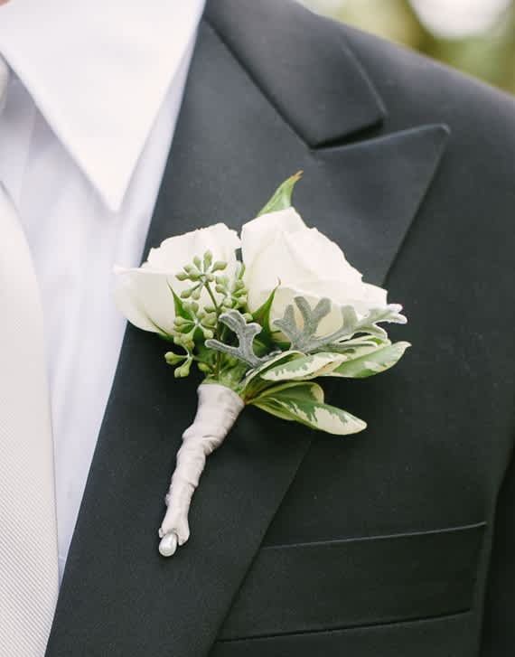 Boutonniere in White - This classic white boutonniere is always a sure hit and will match almost any attire.  Hand made with a white spray rose and fresh greenery. 