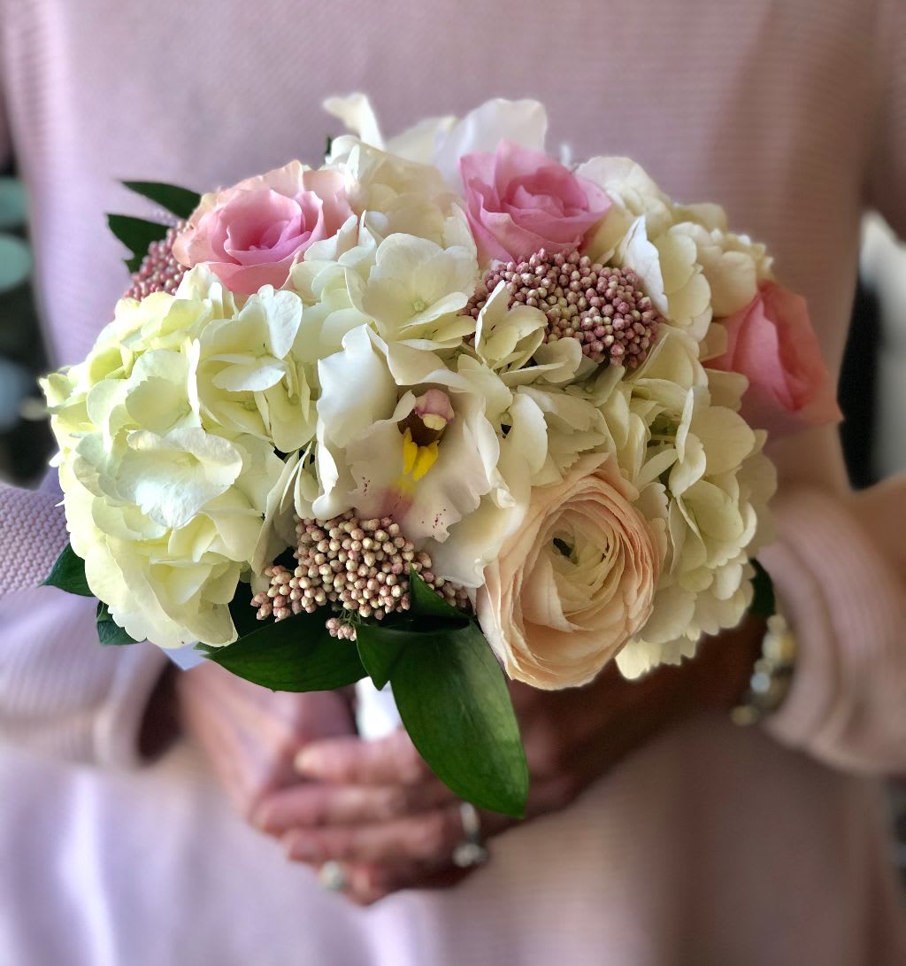 Cotton Candy Blooms Handheld  - Pink roses, blush ranunculus, pink riceflowers, and white cymbidium orchids are nestled among white hydrangea blooms. ***Deluxe Shown*** Standard is slightly smaller. Tax free, same day hand delivery.