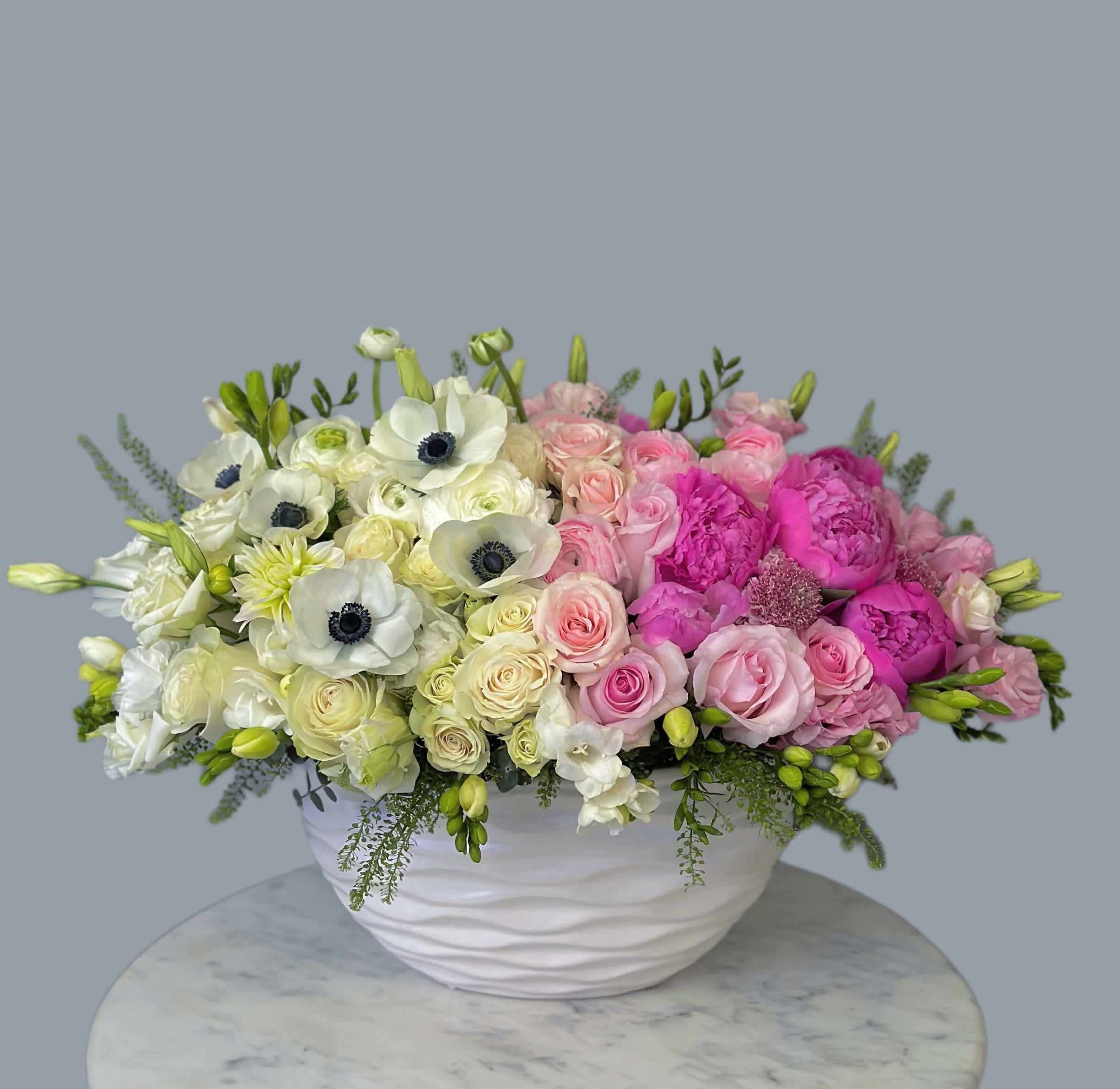 Pink &amp; White Arrangement  - A pink arrangement in a vase with white and pink flowers can look very delicate and elegant. The vase may hold softly pink roses, creating the base of the arrangement, while white lilies add freshness and grace. Additionally, white chrysanthemums or peonies can be used to add volume and texture. To add extra charm, some greenery like eucalyptus or asparagus fern can be added to create a fuller and more harmonious look to the composition.